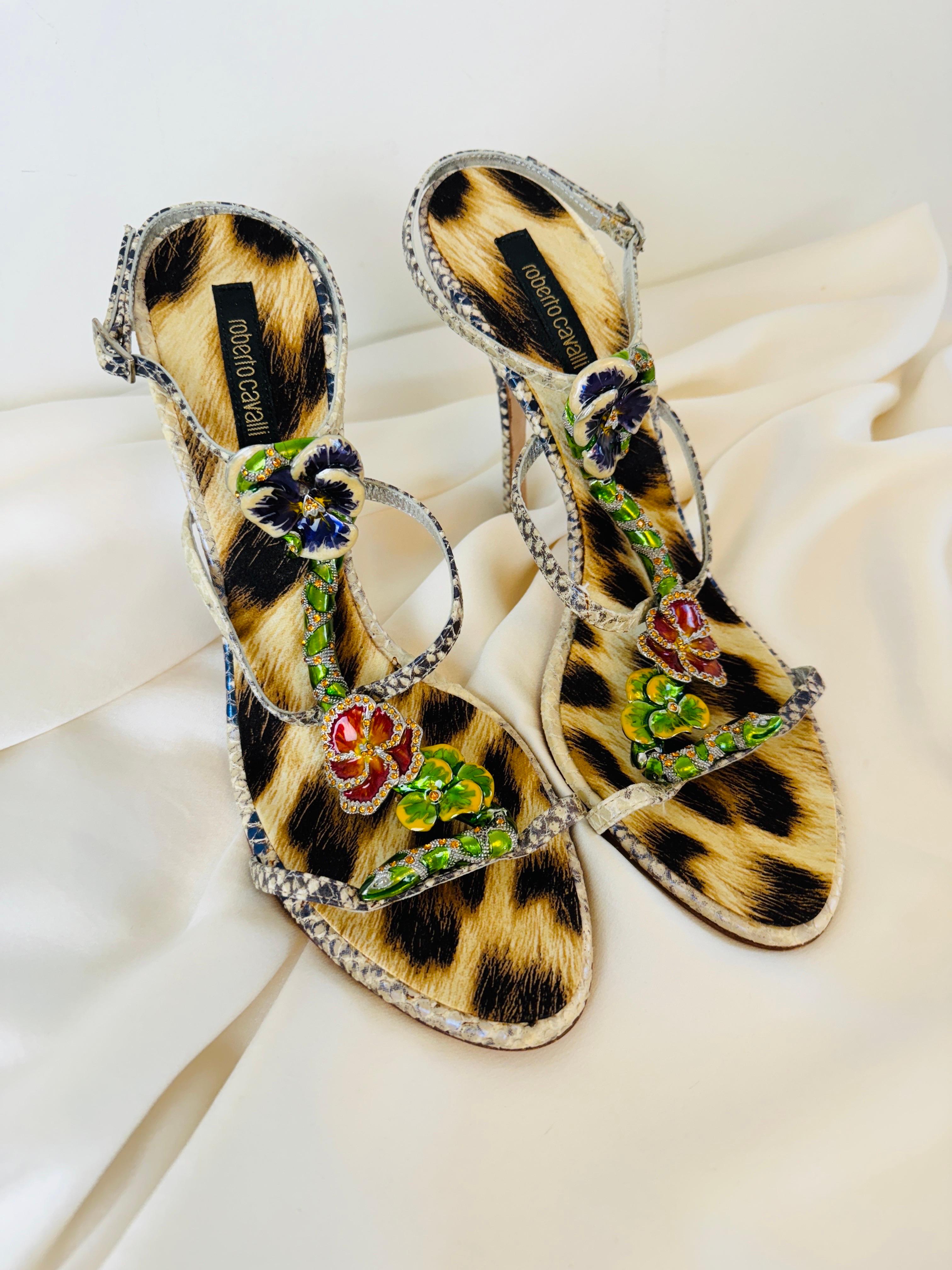 Vintage 2000s Roberto Cavalli heels
Ankle wrap style with silver buckle closure
Ornate enamel + rhinestone snake + flower details on the front supported by 3 straps across the shoe
Leopard foot bed
Grey + off white iridescent snake pattern leather