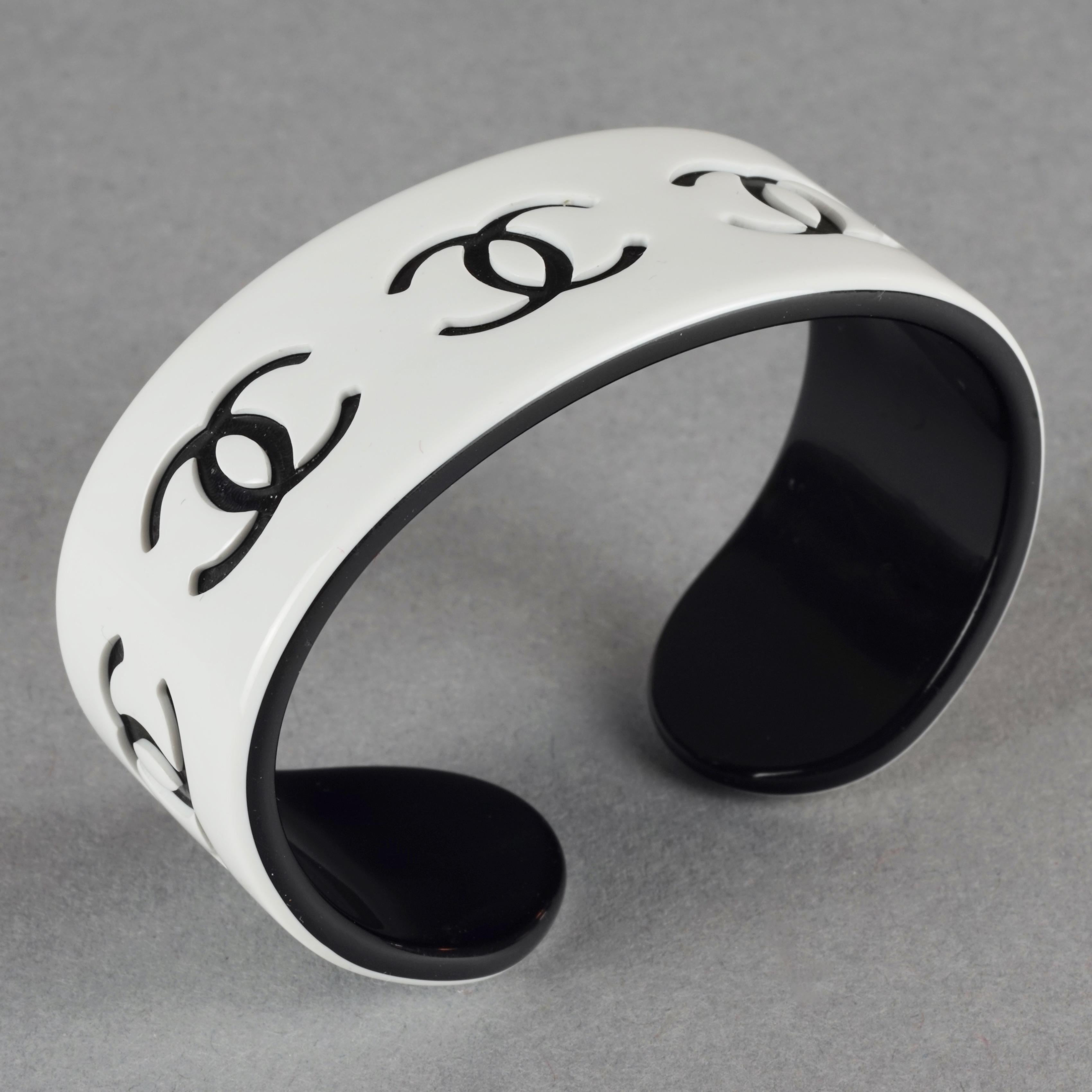 Vintage 2002 CHANEL White and Black CC Logo Perspex Cuff Bracelet

Measurements:
Height: 0.86 inch (2.2 cm)
Maximum Circumference: 6.10 inches (15.5 cm) including the opening

Features:
- 100% Authentic CHANEL.
- White perspex cuff bracelet with
