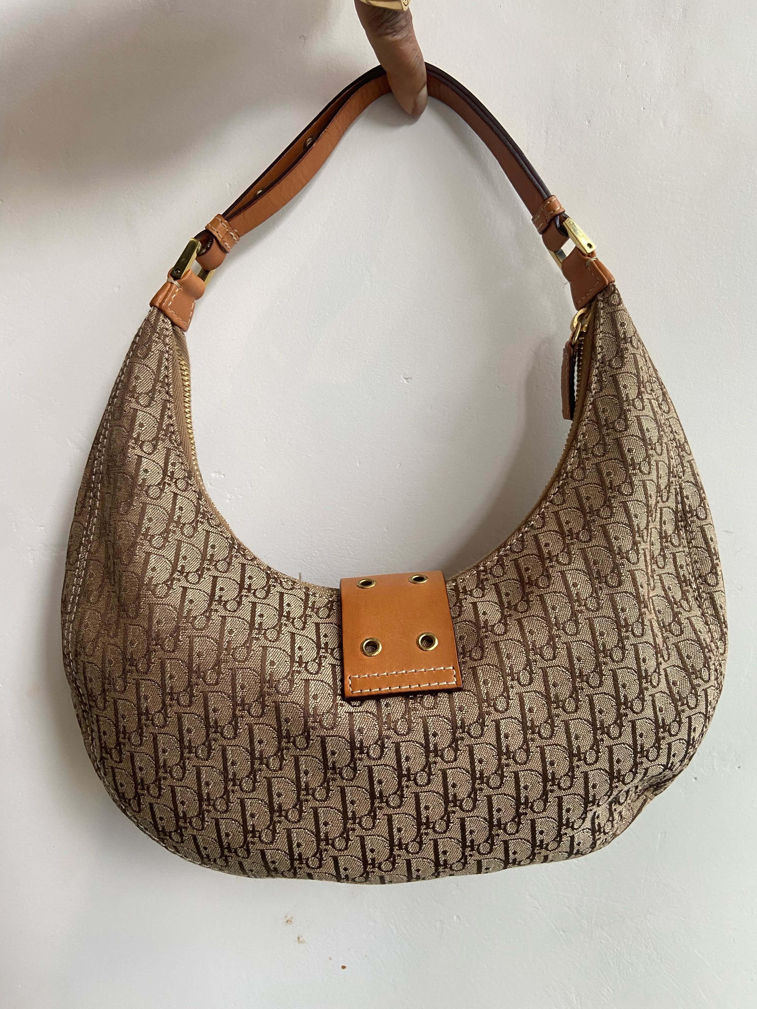 Christian Dior by John Galliano 2003 half moon hobo monogram handbag. Features Dior hardware, moon shape, canvas body, cowhide leather features, inside zip back pocket and shoulder strap. In good vintage condition. 

Brand: Christian Dior
Color: