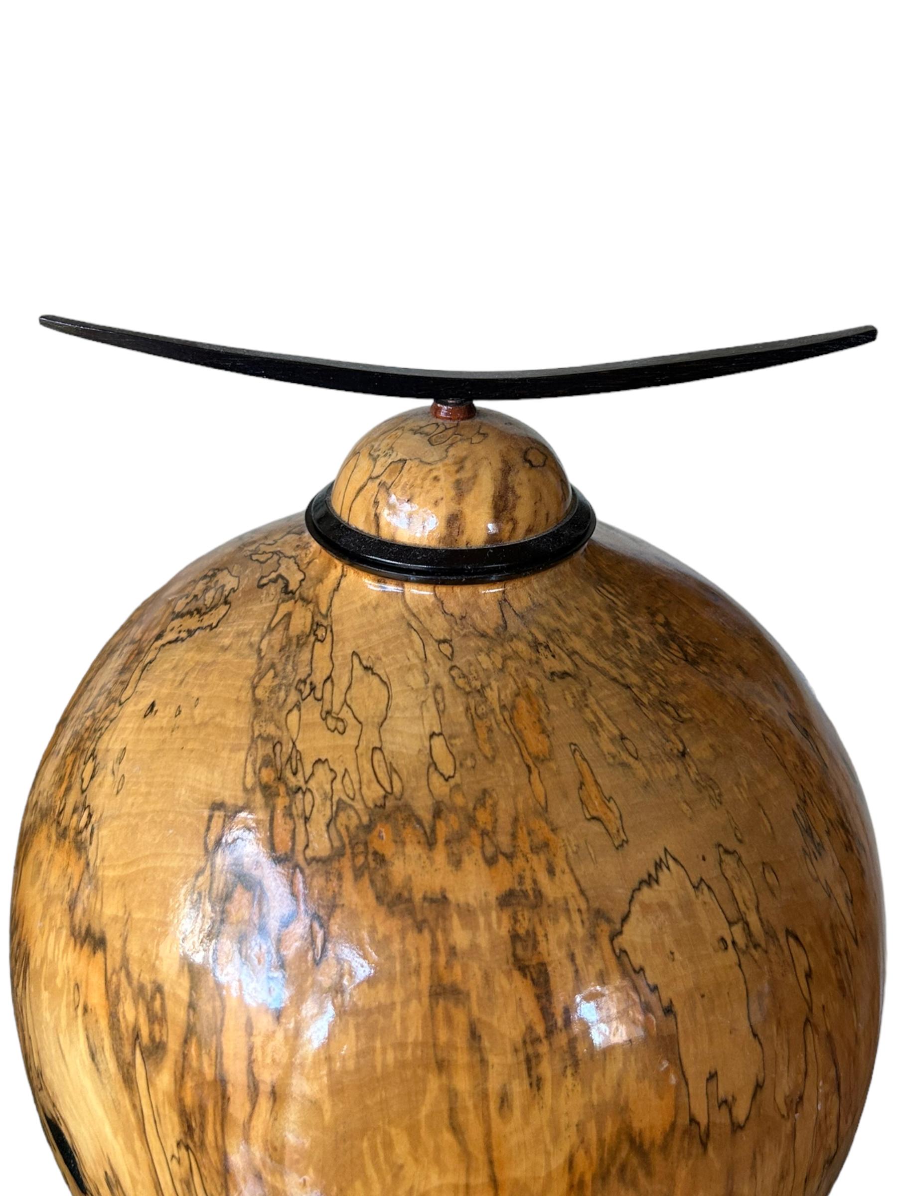 This vintage sculpture vessel by John Mascoll is a unique piece of art that will stand out in any collection. Crafted from red maple wood, this sculpture showcases the artist’s talent and creativity.  John studied engineering in the US and designed