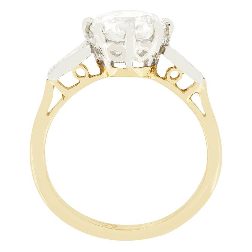 This beautiful vintage solitaire ring features a sparkling 2.00 carat diamond at its centre. The stone has been given a J in colour and SI1 in clarity and is claw set into platinum. Down each shoulder, the central stone is flanked by a pair of 0.05