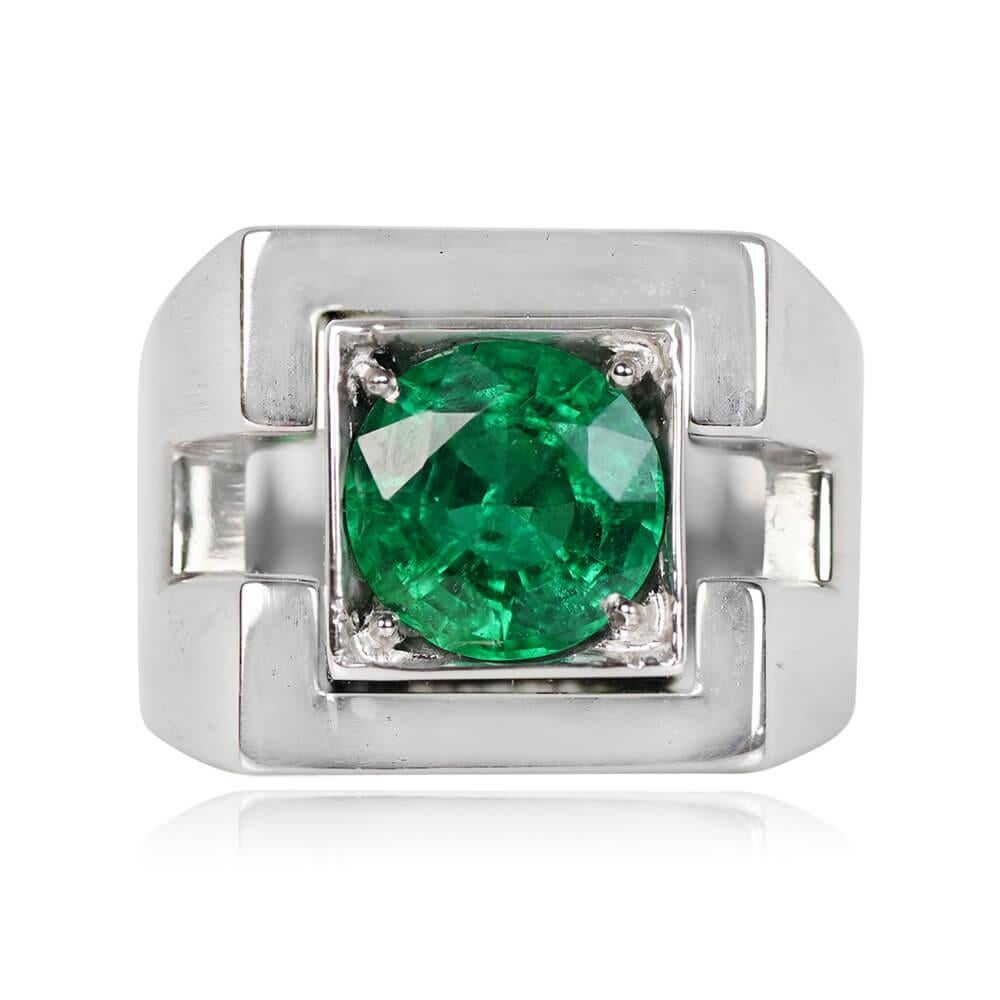 A timeless vintage French emerald ring showcasing a 2.01-carat round-cut natural emerald, delicately cradled in prongs within a square bezel. The 18k white gold mounting boasts intricate geometric cut-outs on the shoulders, adding a touch of