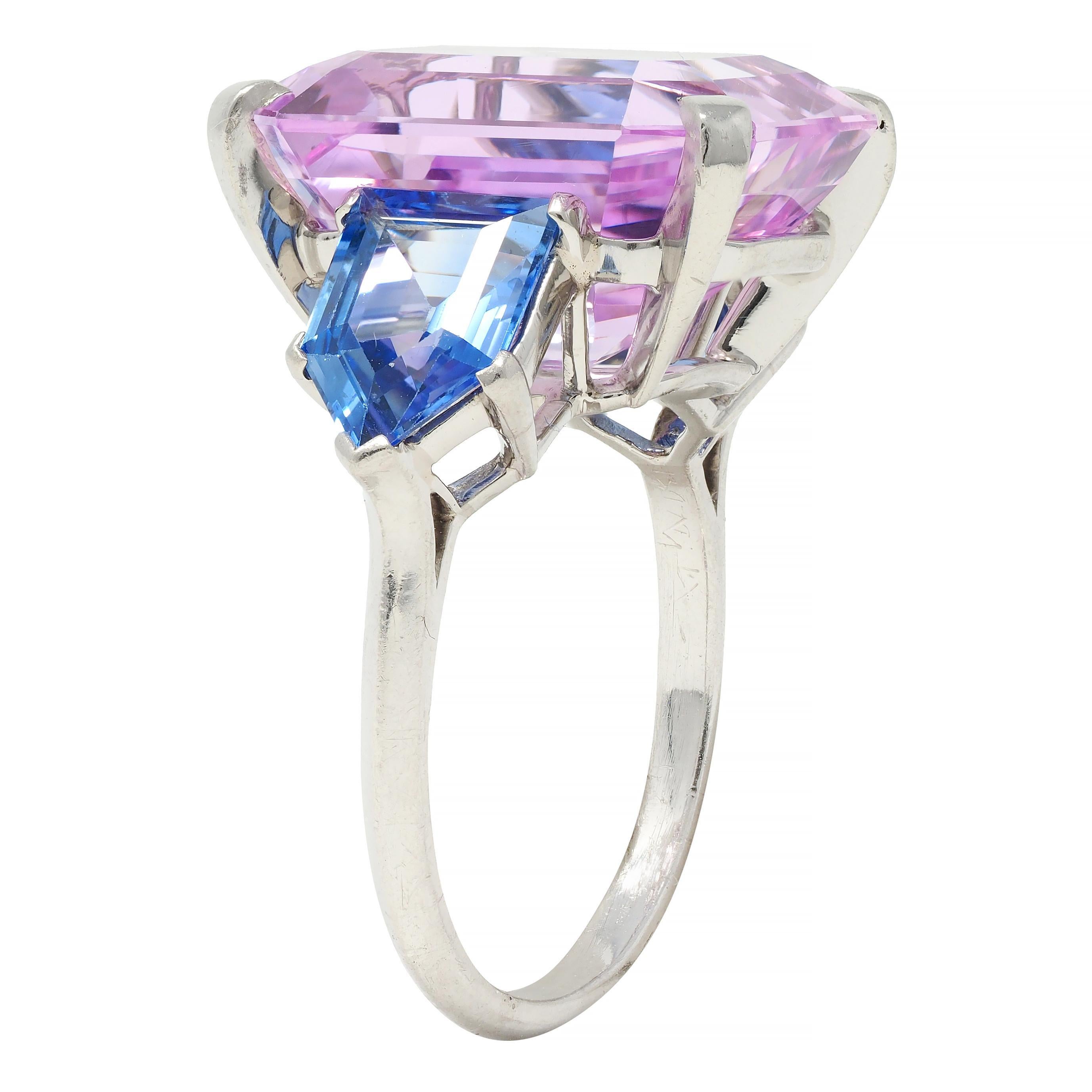 Centering an emerald cut imperial topaz weighing approximately 17.64 carats total 
Natural and transparent light pink in color - set with tab prongs in basket 
Flanked by shield cut sapphires weighing approximately 2.60 carats total 
Natural Ceylon