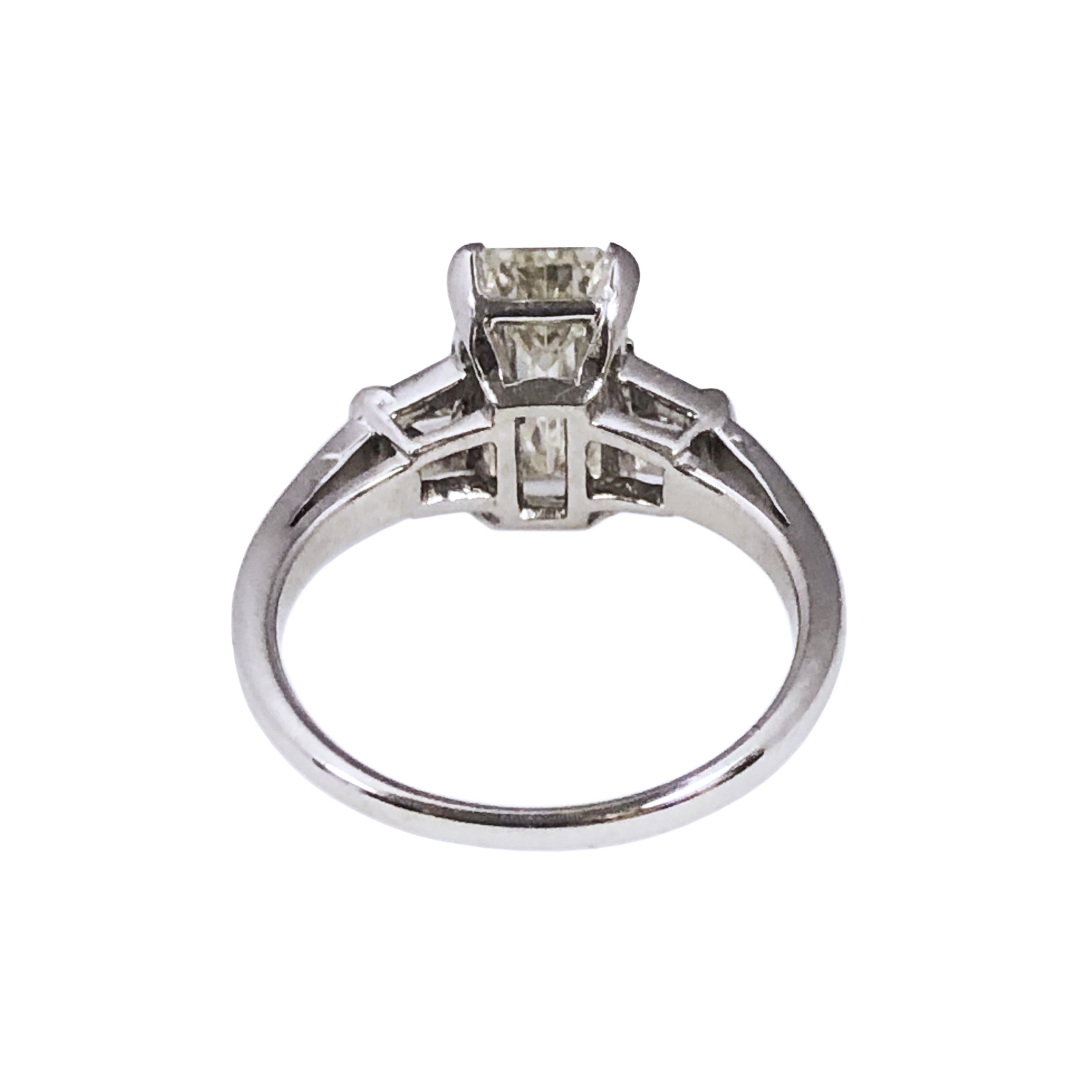 Circa 1950 Platinum and Diamond Ring, centrally set with a 2.07 Carat Elongated Step cut, Emerald cut Diamond Grading as L in Color ( Faces up much whiter ) and SI1 in clarity, Set on either side with Tapered Baguette Diamonds. Finger size 5 3/4.