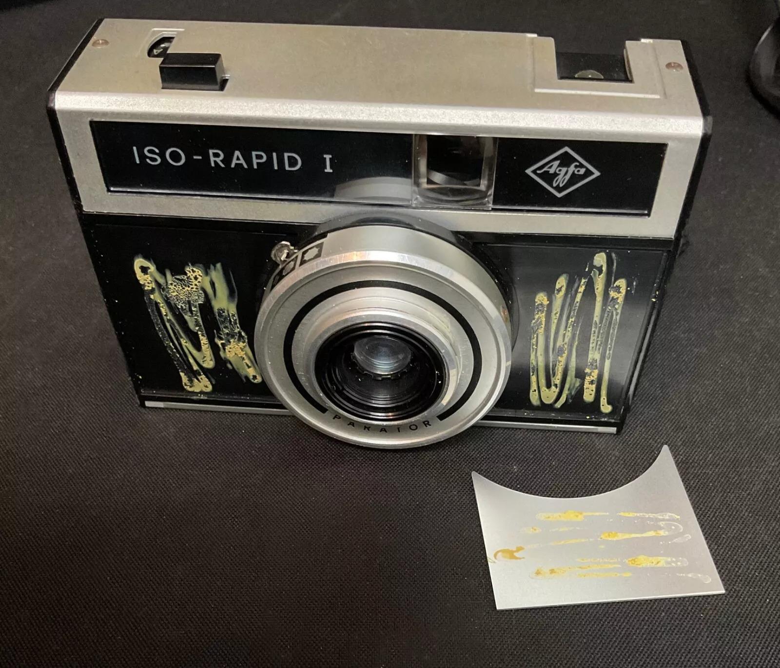 Entrez dans l'histoire de la photographie avec cet appareil photo vintage Agfa isa-Rapid 1 du 20e siècle, accompagné de son étui d'origine. Compact et léger, il mesure 7 cm x 11 cm x 3,5 cm (2,76 in x 4,33 in x 1,38 in) et pèse 300 g (0,66 lb). Bien