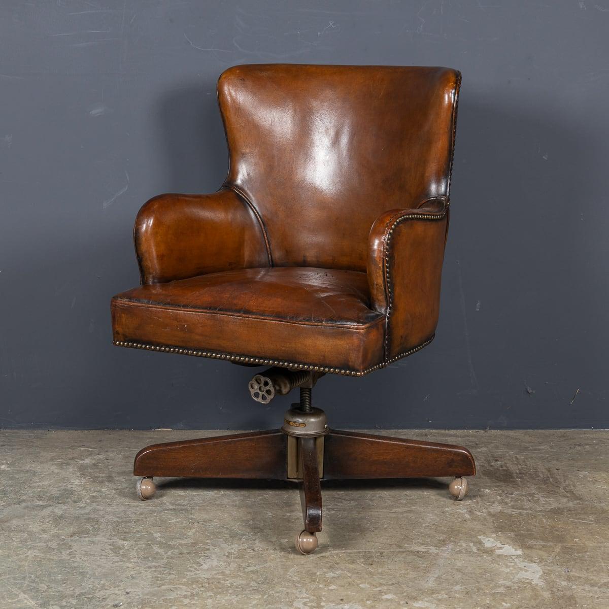 A mid 20th Century British made Hillcrest revolving leather office chair. Made by the British company Hillcrest, in tan leather over wood & brass details. The company was one of the first to devise a mechanism to raise and lower the seat of a