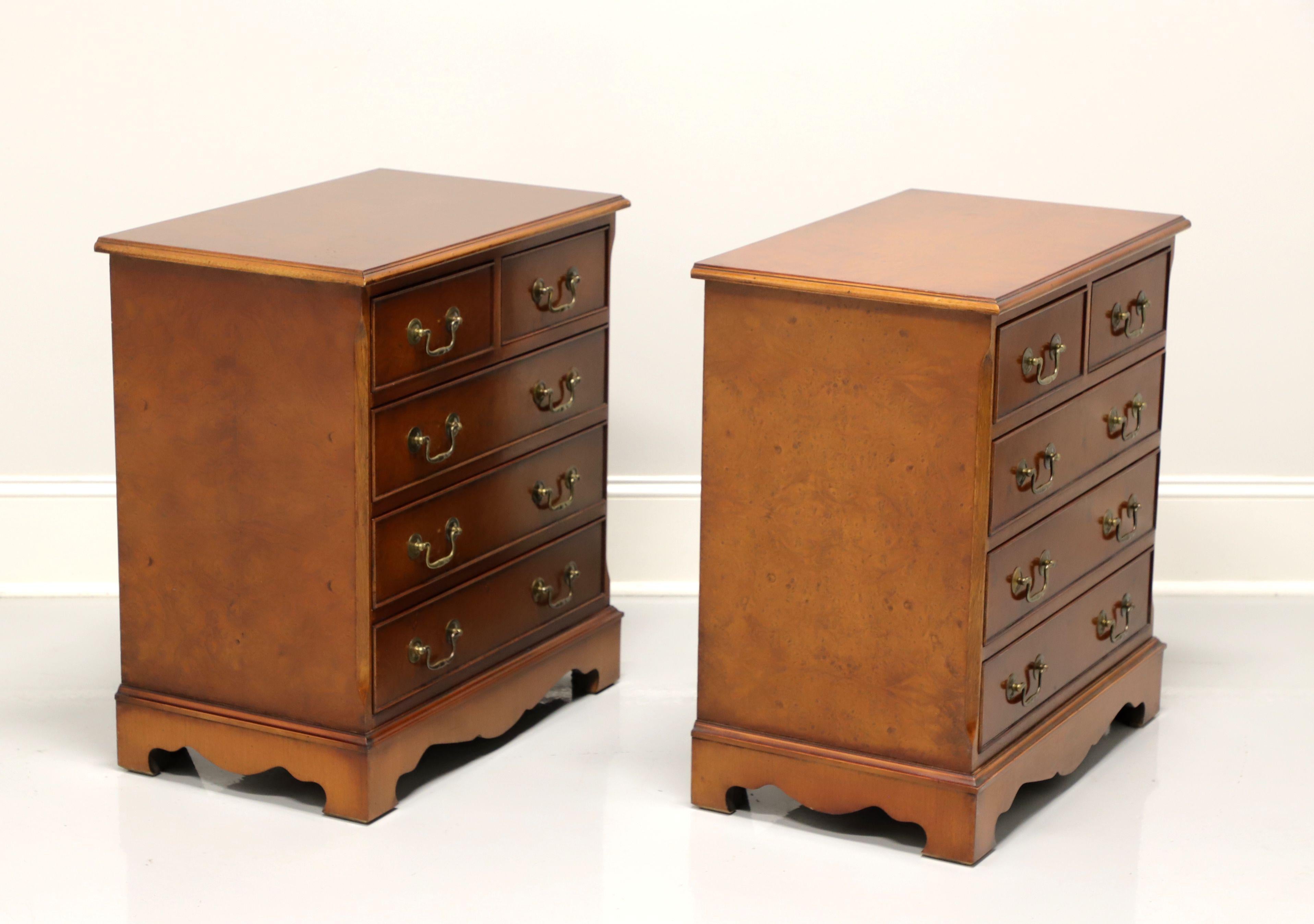 A pair of Chippendale style nightstands, unbranded, similar in quality to Baker. Burl walnut with brass hardware and bracket feet. Features two smaller over three larger drawers of dovetail construction. Made in the USA, in the mid 20th
