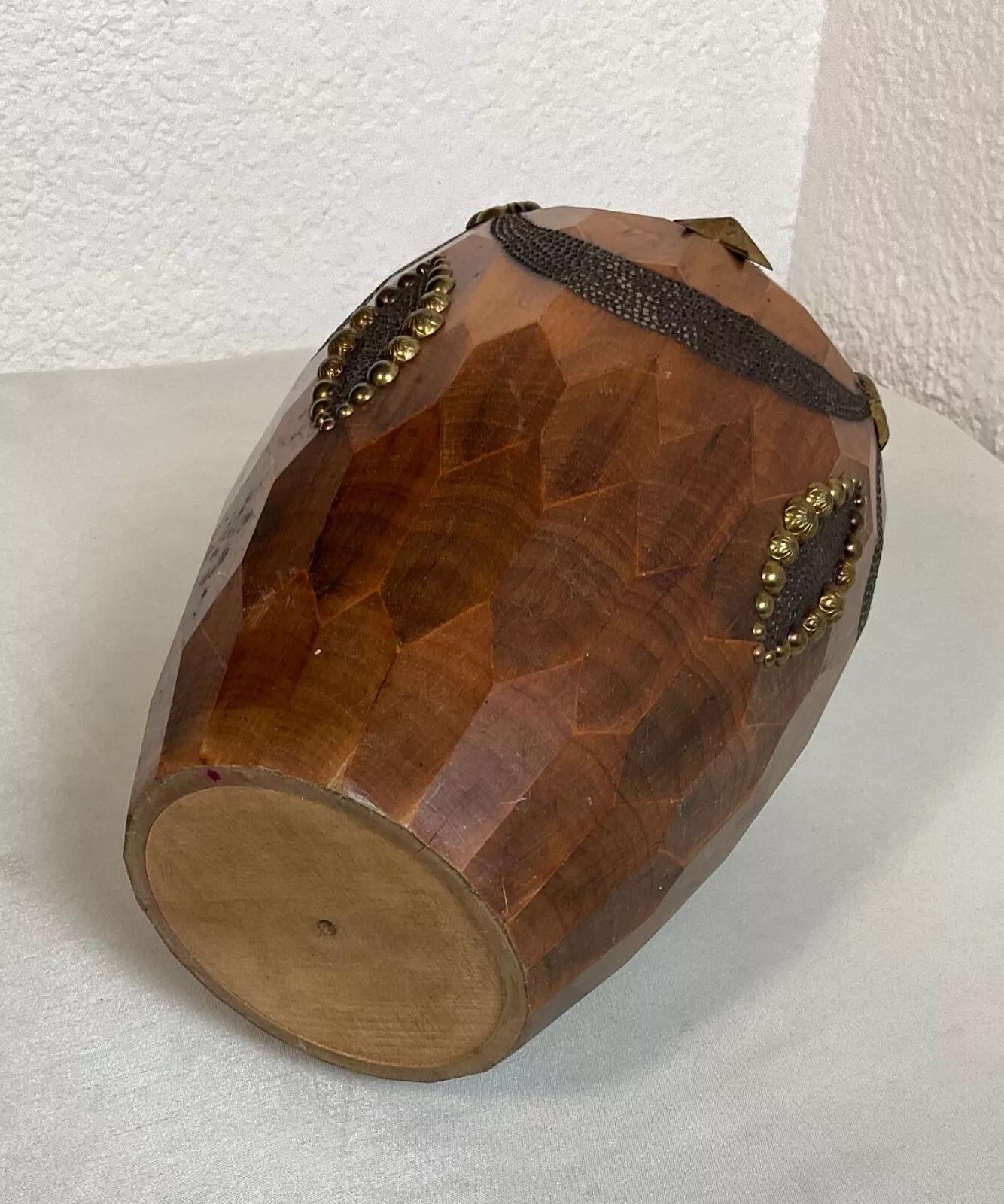 This is a vintage 20th-century decorative vase made from wood and brass. The body of the vase is crafted from wood with a striking carved geometric pattern, giving it a faceted appearance. It is adorned with various brass decorations, including