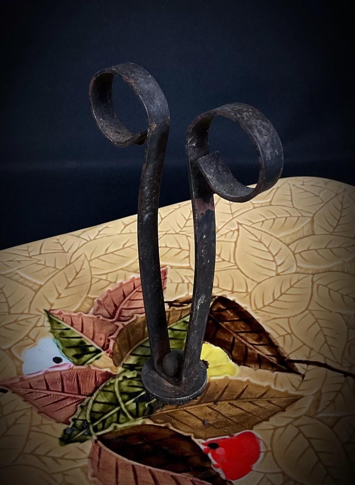 This charming vintage cheese serving platter from the 20th century showcases a beautiful hand-painted fruit and leaf motif, adding a touch of rustic elegance to any table. The platter features a sturdy wrought iron handle, enhancing its classic
