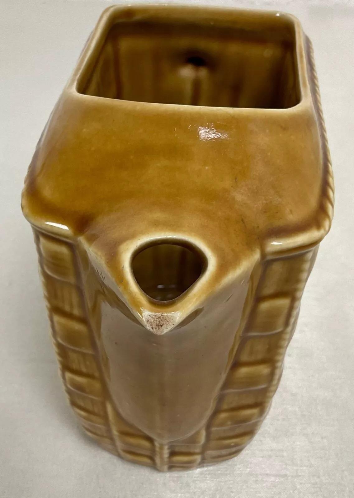 Ce pichet en céramique vintage du 20e siècle est une pièce charmante et fonctionnelle, fabriquée à la main. Mesurant 6,3 pouces (16 cm) de hauteur, 8,1 pouces (20,5 cm) de longueur et 3,7 pouces (9,5 cm) d'épaisseur, ce pichet pèse 2,1 livres (951