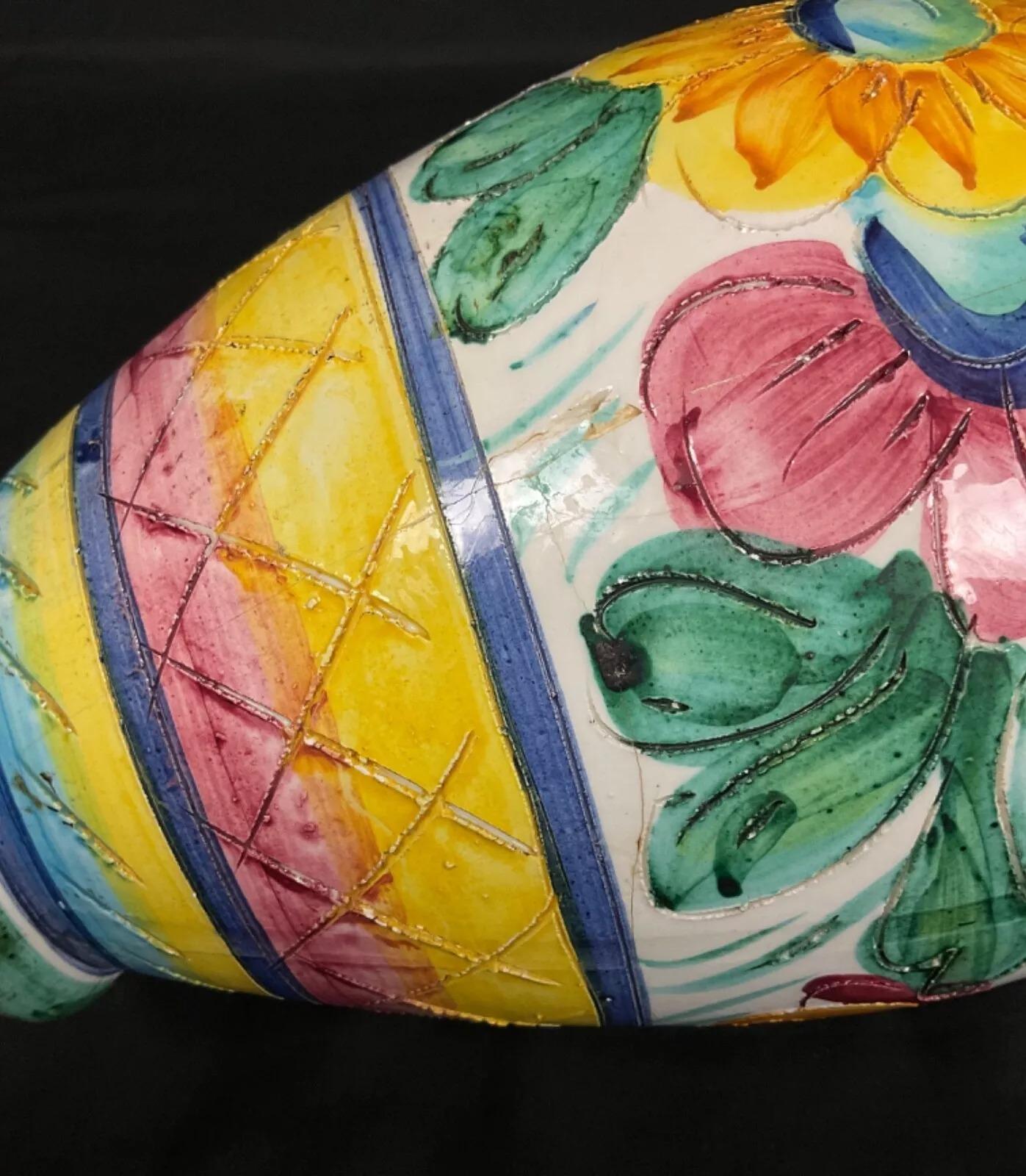 Ce charmant vase en céramique vintage du XXe siècle, orné d'un délicat motif floral, est une pièce décorative captivante. Mesurant 11,6 pouces (29,5 cm) de hauteur et 5,9 pouces (15 cm) de diamètre, il pèse 2,38 livres (1,082 kg). Sa forme élégante