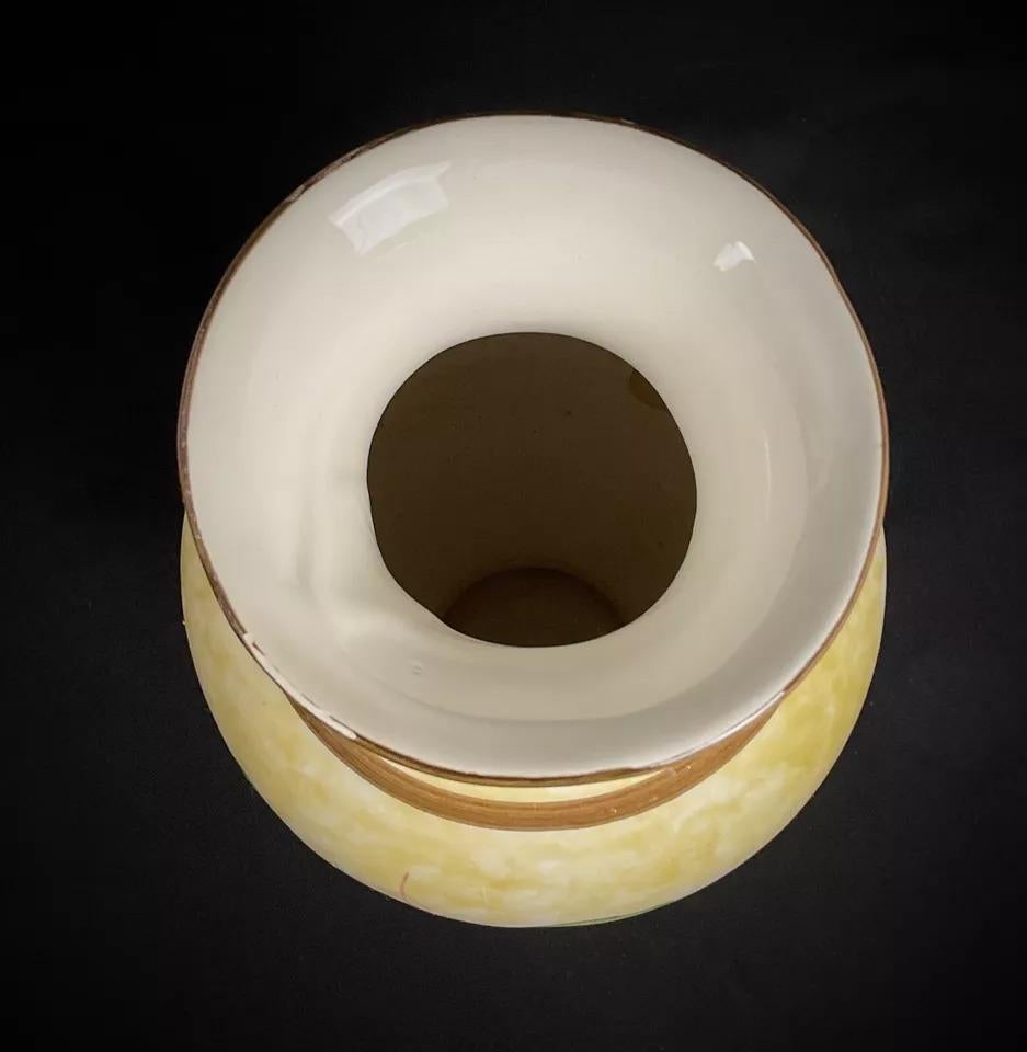 Questo vaso in ceramica vintage del XX secolo presenta un elegante disegno di frutta e fiori che lo rende un'aggiunta affascinante a qualsiasi collezione o esposizione. Con un'altezza di 25 cm e un diametro di 10,5 cm, il vaso pesa 621 g. La sua