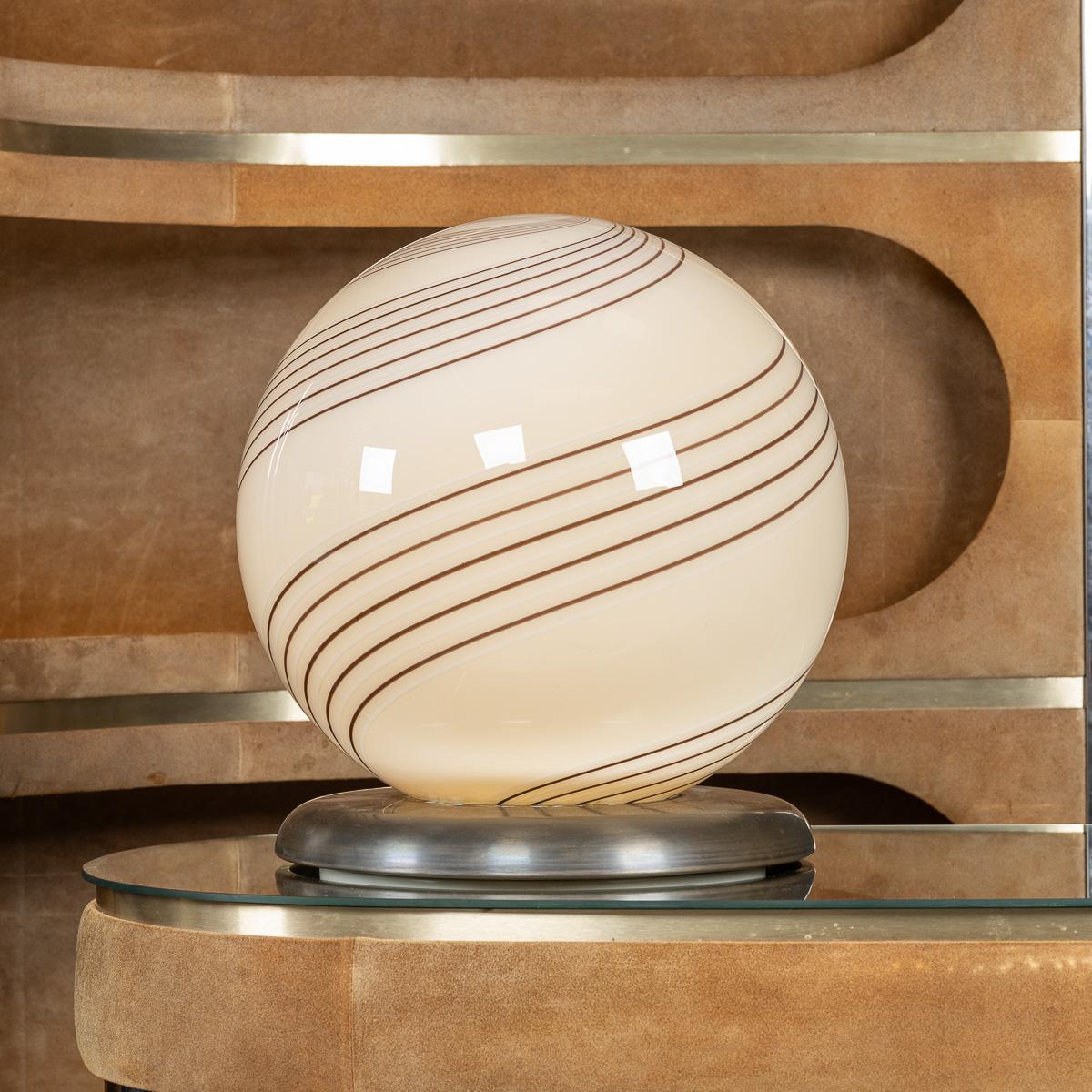 Une élégante lampe d'appoint en verre crème, fabriquée en Italie, vers 1980, mettant en valeur l'art raffiné de la verrerie italienne. La lampe présente un design frappant de fines lignes concentriques brunes rayonnant du point central en haut