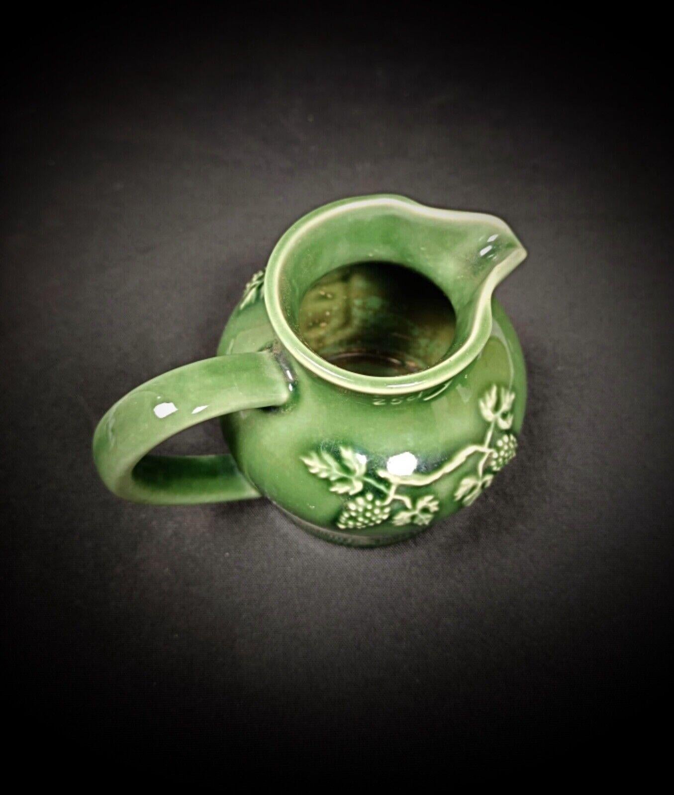 Questa incantevole brocca in porcellana vintage del XX secolo presenta un bellissimo disegno smaltato di uva e foglie di vite. I dettagli delicati dei grappoli d'uva e delle foglie rendono questo pezzo un'aggiunta deliziosa a qualsiasi collezione o