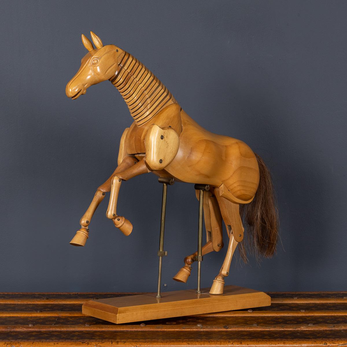 Cheval en bois articulé du 20e siècle, monté sur un socle en laiton avec une base en bois. Les quatre pattes, la tête et le cou sont mobiles. Son design intemporel lui permet de s'intégrer parfaitement dans les intérieurs modernes et