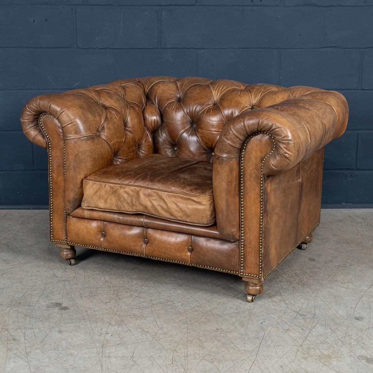 Un sillón Chesterfield moderno de magnífica calidad que es toda una declaración de elegancia y artesanía. Acabado en rica piel marrón, presenta el clásico mechón de botones, los brazos enrollados y la robusta estructura que definen el diseño