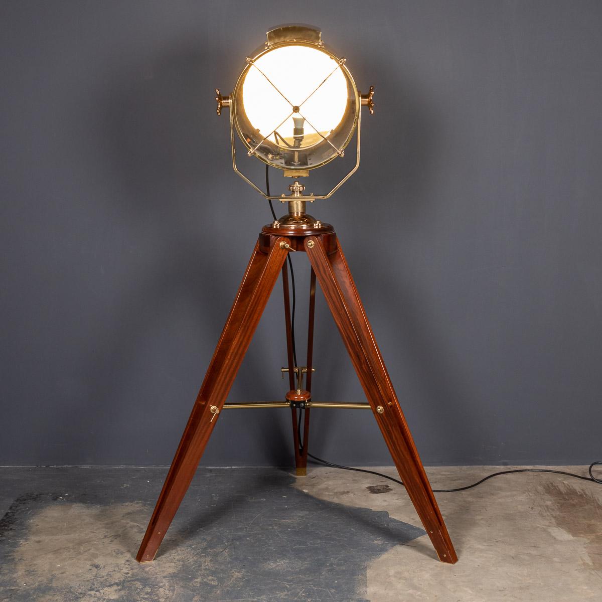 A fantastic mid-20th century English polished brass naval searchlight, mounted on a later tripod. These lamps would have been mounted on military or shipping vessels. This example has been professionally polished and rewired to make for a fantastic