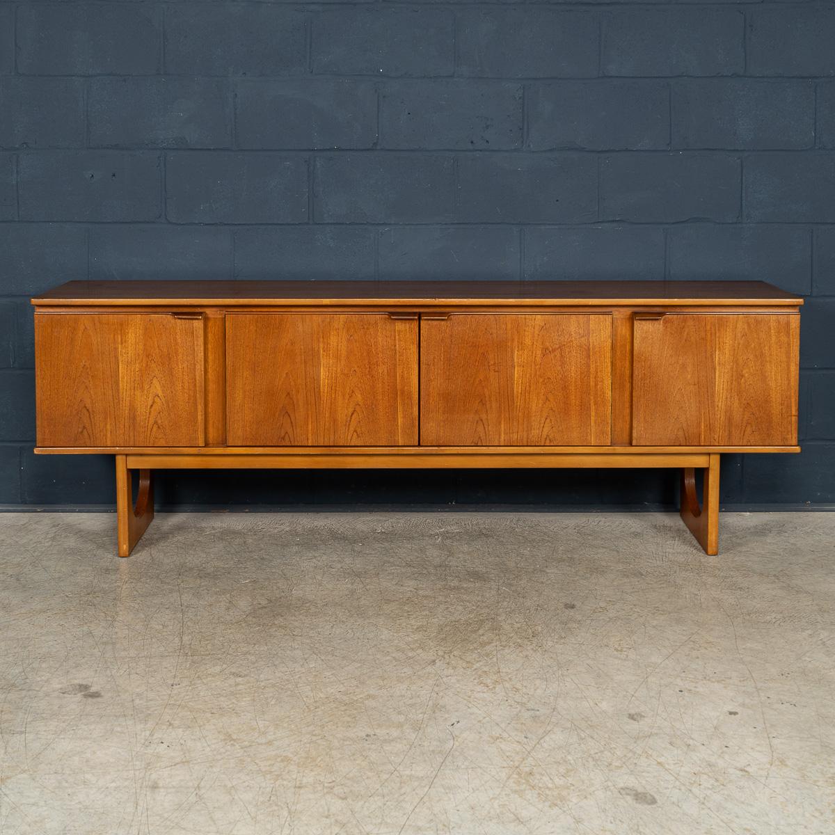 A stunning English sideboard from the mid 20th century, crafted entirely in teak wood, which was highly fashionable during the 1960s. These sideboards have recently experienced a well-deserved resurgence in popularity, as mid century furniture