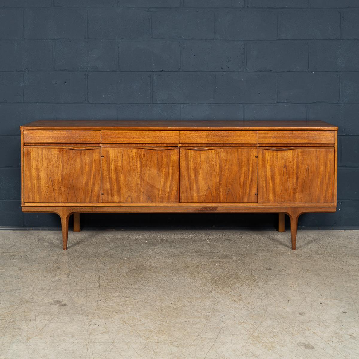 A beautifully crafted English sideboard from the mid twentieth century, realised entirely in richly grained teak, a hallmark of 1960s design. This piece embodies the best of the era’s craftsmanship and aesthetic, with clean lines, gently tapered