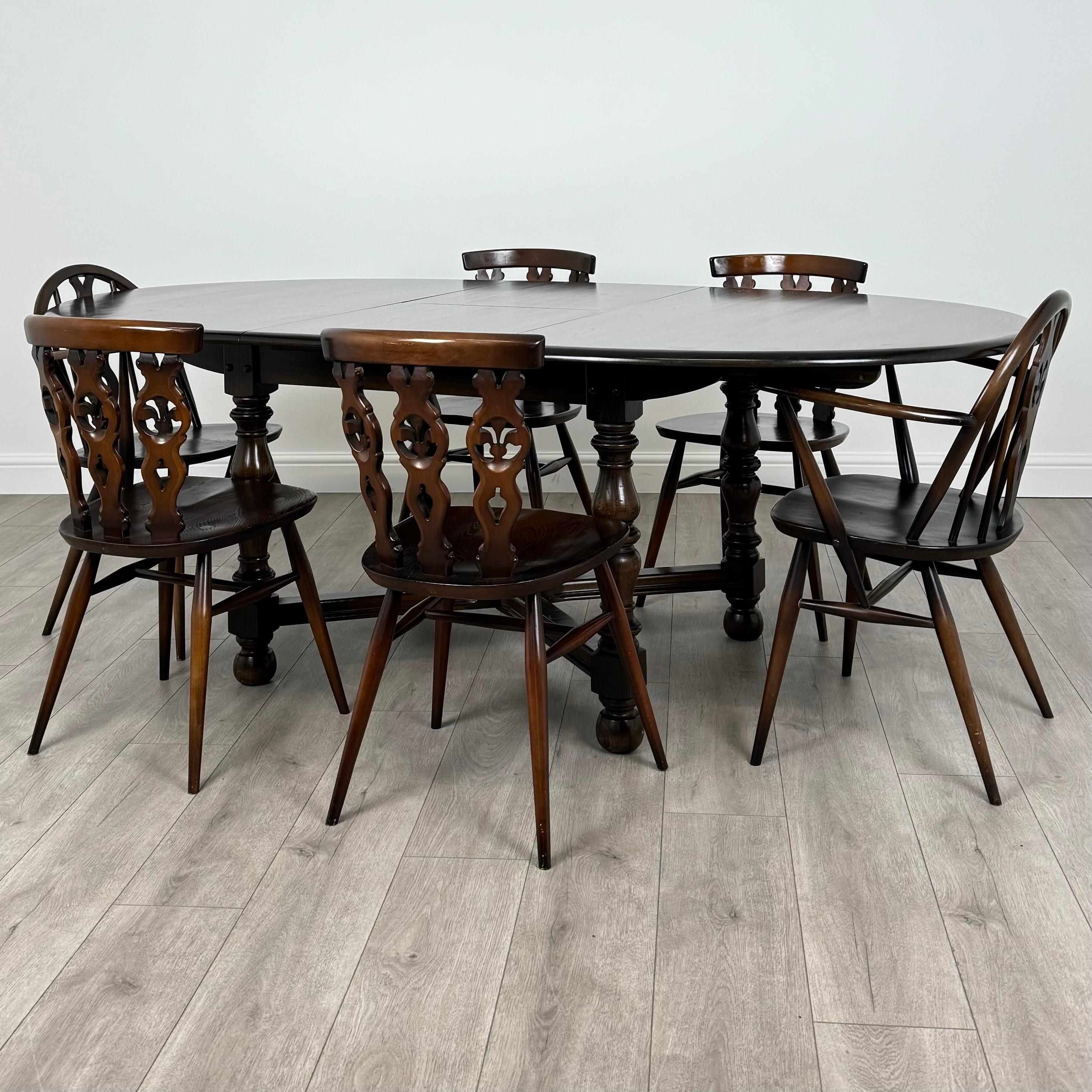 Cette table à manger extensible du 20e siècle avec 6 chaises, fabriquée par le célèbre fabricant de meubles Ercol, est un ajout magnifique et fonctionnel à n'importe quelle maison. 
Fabriqué en orme de haute qualité, l'ensemble bénéficie d'une