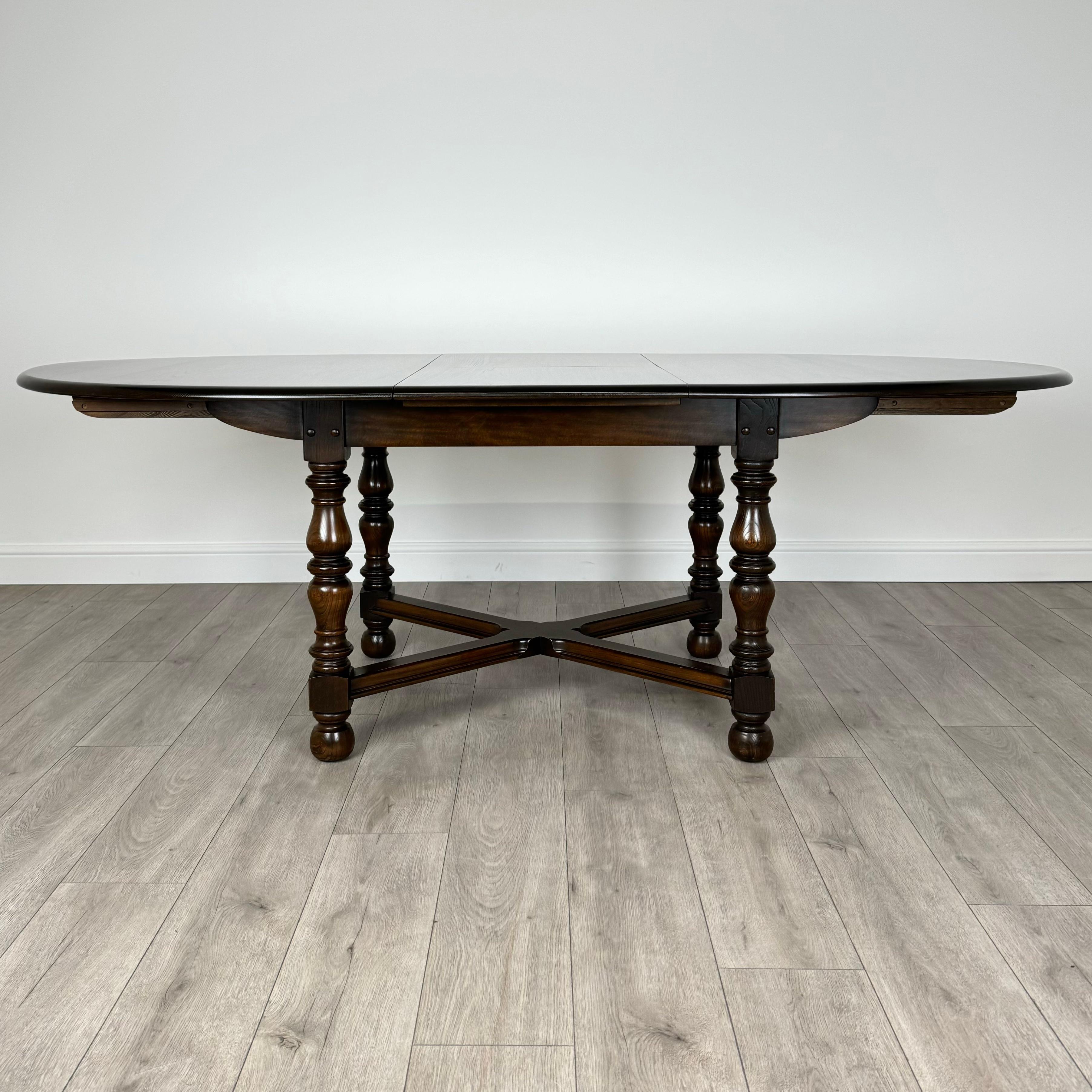 This vintage 20th-century extending dining table, crafted by the renowned furniture maker Ercol, is a stunning piece of furniture that combines functionality with timeless elegance. 
Made from high-quality elm, the table showcases magnificent grain