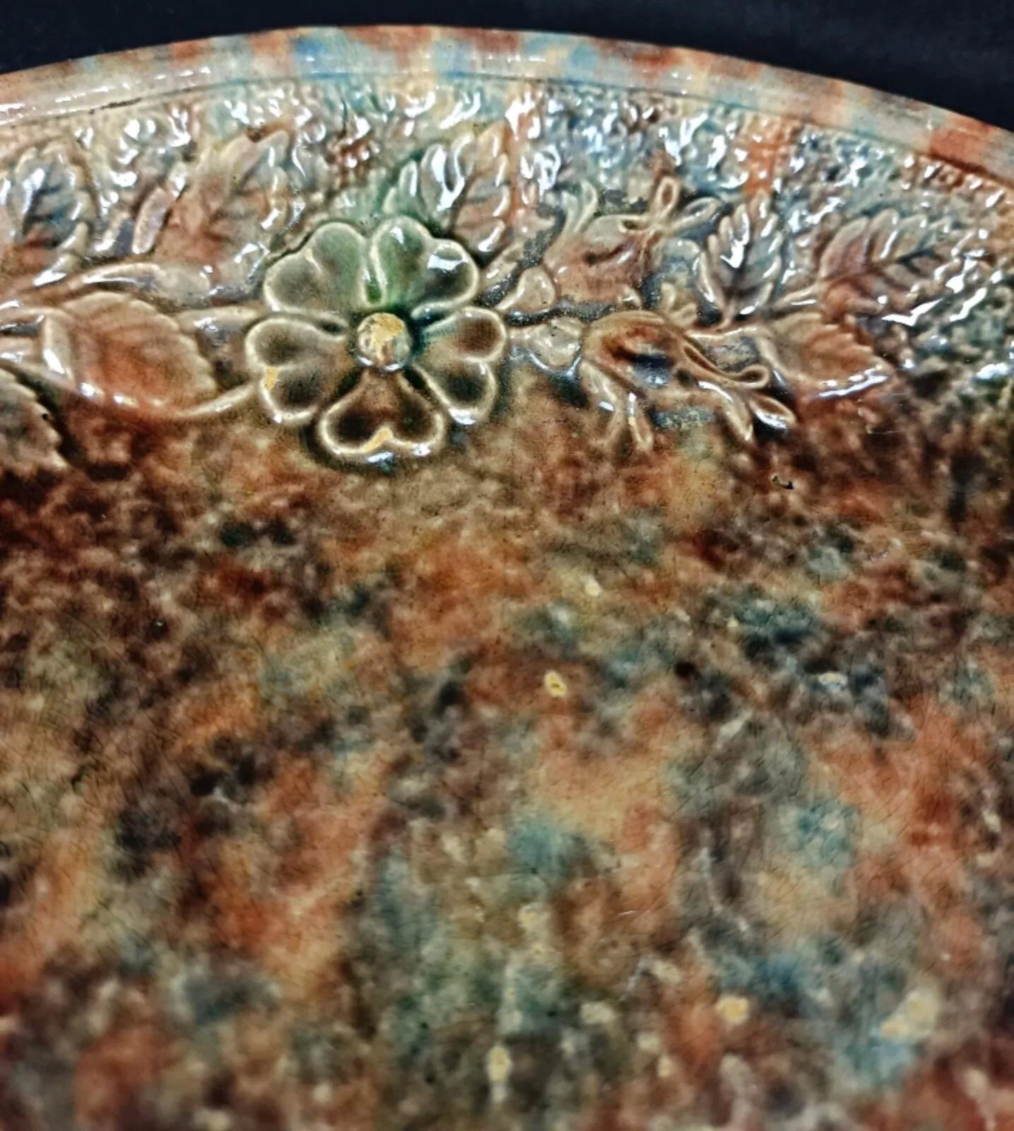 Esta encantadora fuente vintage del siglo XX presenta un precioso diseño floral, que la convierte en un elegante complemento para cualquier comedor. La fuente es de cerámica y está acabada con detalles pintados a mano. A pesar de su antigüedad, se