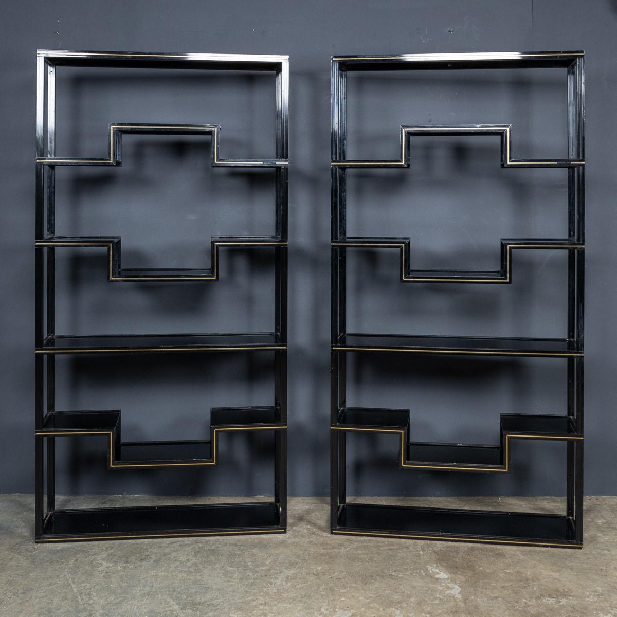 An elegant pair of Vintage 20th Century French made, black metal with brass detailed etagere display shelves, comprising of six staggered, smoked glass shelves of varying dimensions. Designed by Pierre Vandel and manufactured in the 1970s, this