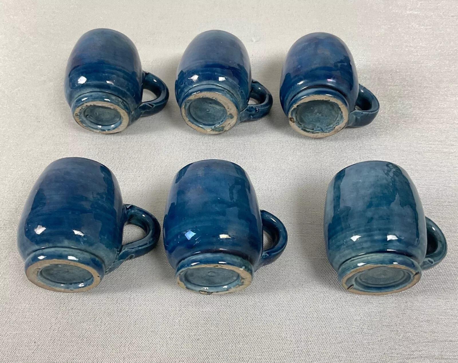 Questo set da tavolo francese vintage del XX secolo è un pezzo affascinante e decorativo, perfetto per i collezionisti o come oggetto da esposizione unico. Il set comprende un barile di legno e sei piccole tazze di ceramica, montate su un supporto