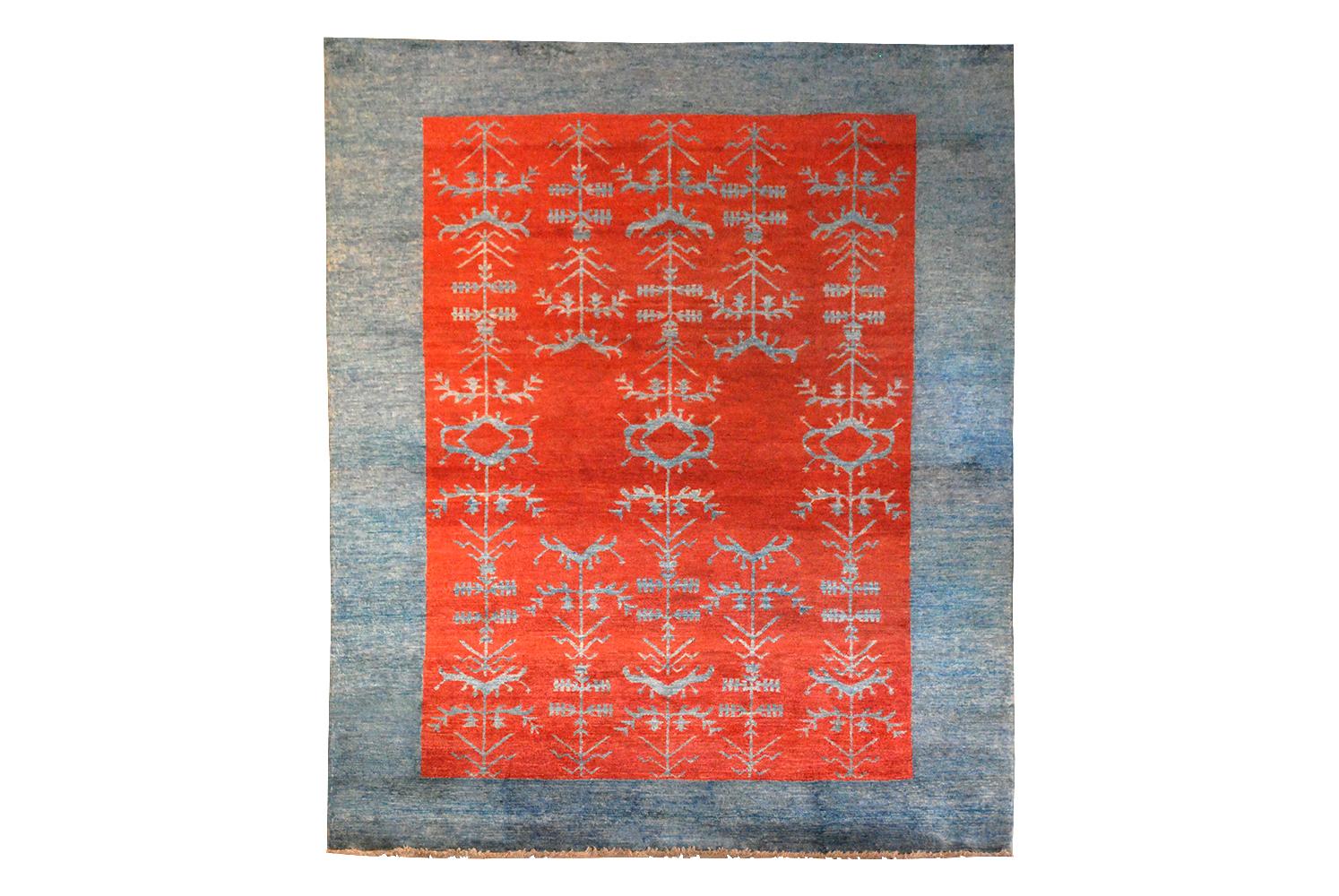 Hand knotted Gaba wool rug. Blue striaed background with striking red pattern through centre.