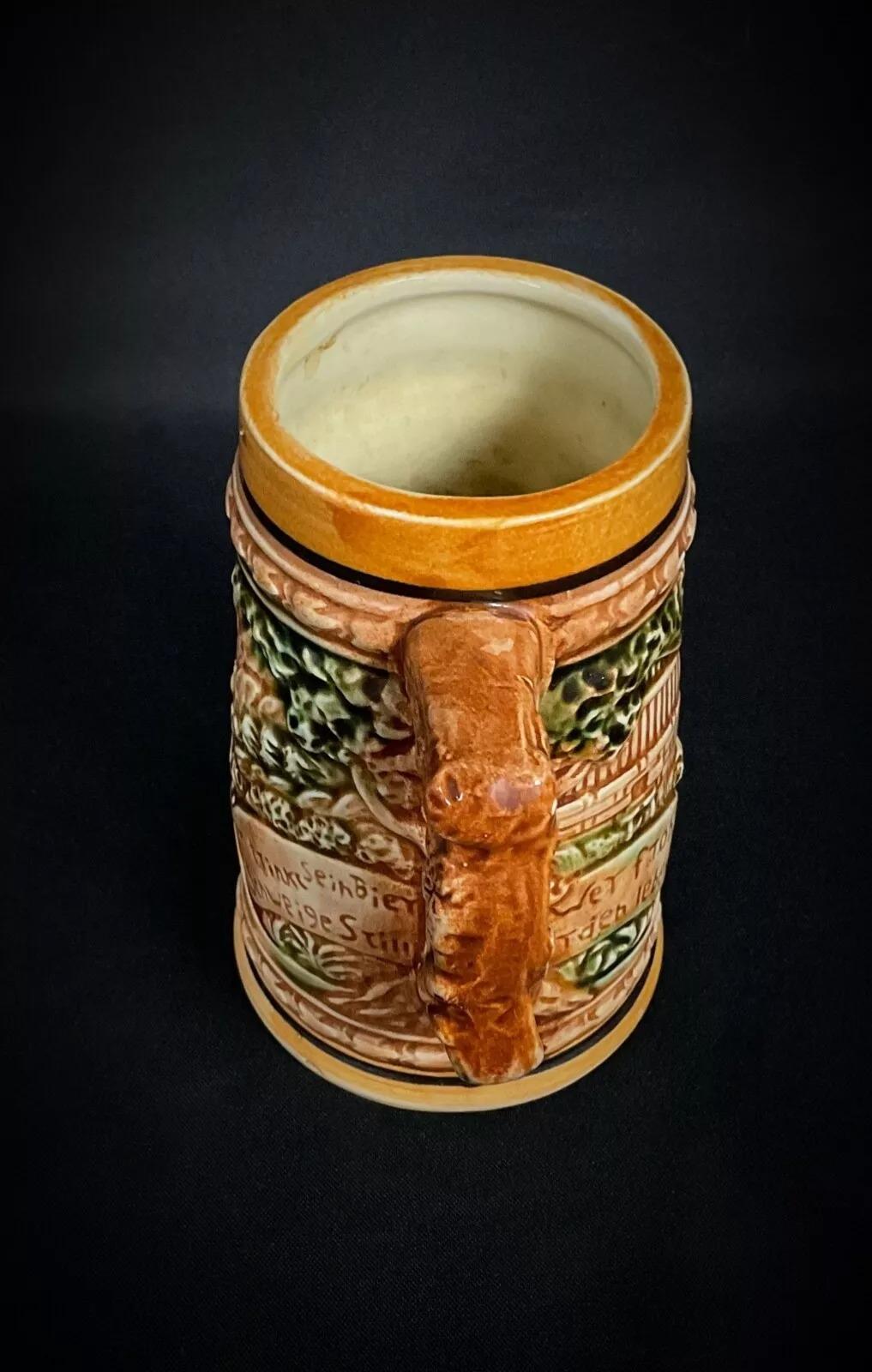 Ce stein à bière allemand du XXe siècle, fabriqué au Japon, est un ajout charmant à toute collection. Mesurant 5,3 pouces (13,5 cm) de hauteur et 3,3 pouces (8,5 cm) de diamètre, ce stein coloré pèse 0,75 lbs (341 g) et présente un design complexe