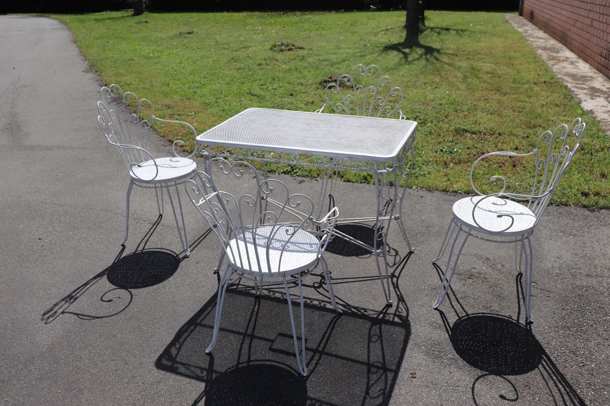 Wunderschöne Gartengarnitur aus Eisen, ca. 1970er Jahre. Vier Sessel und ein rechteckiger Tisch. Raffinierte Eisenverzierung mit Locken und Wirbeln. Das Eisen ist in einem schönen weißen Farbton lackiert worden. Dieses Gartenset ist perfekt, um