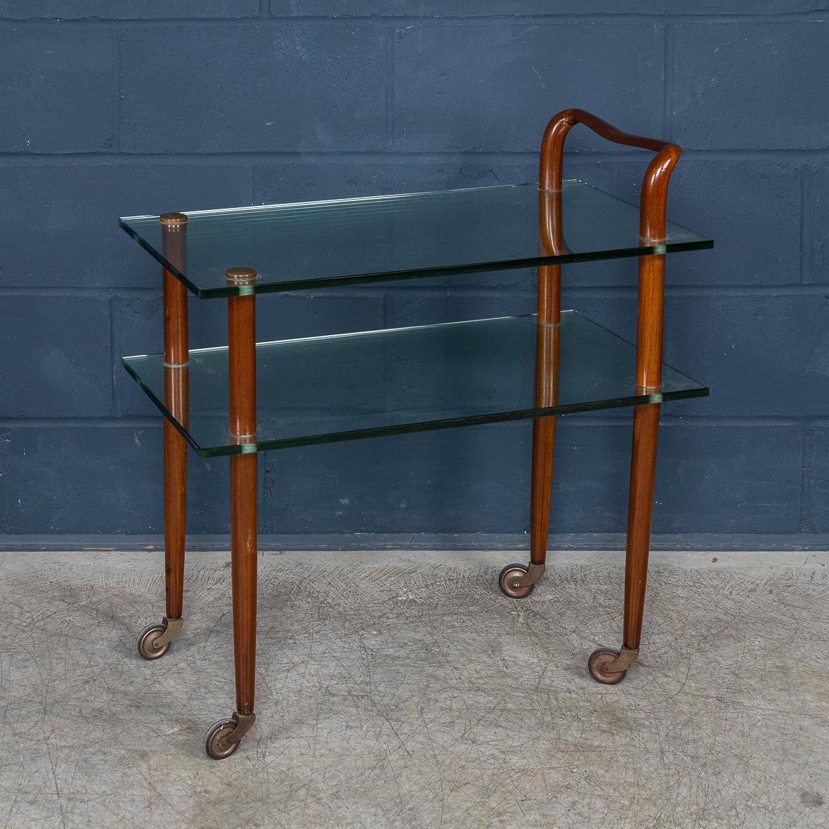 Dieser elegante italienische Getränkewagen aus den 1980er Jahren verbindet die Wärme von reichem Mahagoni mit der Klarheit von zwei Etagen aus dickem gehärtetem Glas. Der anmutig geschwungene Griff weist eine wellenartige Form auf, die dem Design