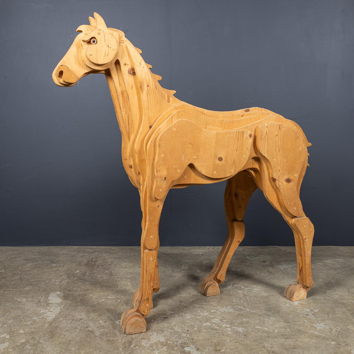 Sculpture de cheval vintage en pin italien du 20e siècle, créée en utilisant la technique du bois stratifié, où les pièces individuelles sont empilées pour former les courbes du corps du cheval. Cette pièce provient d'une école d'art en