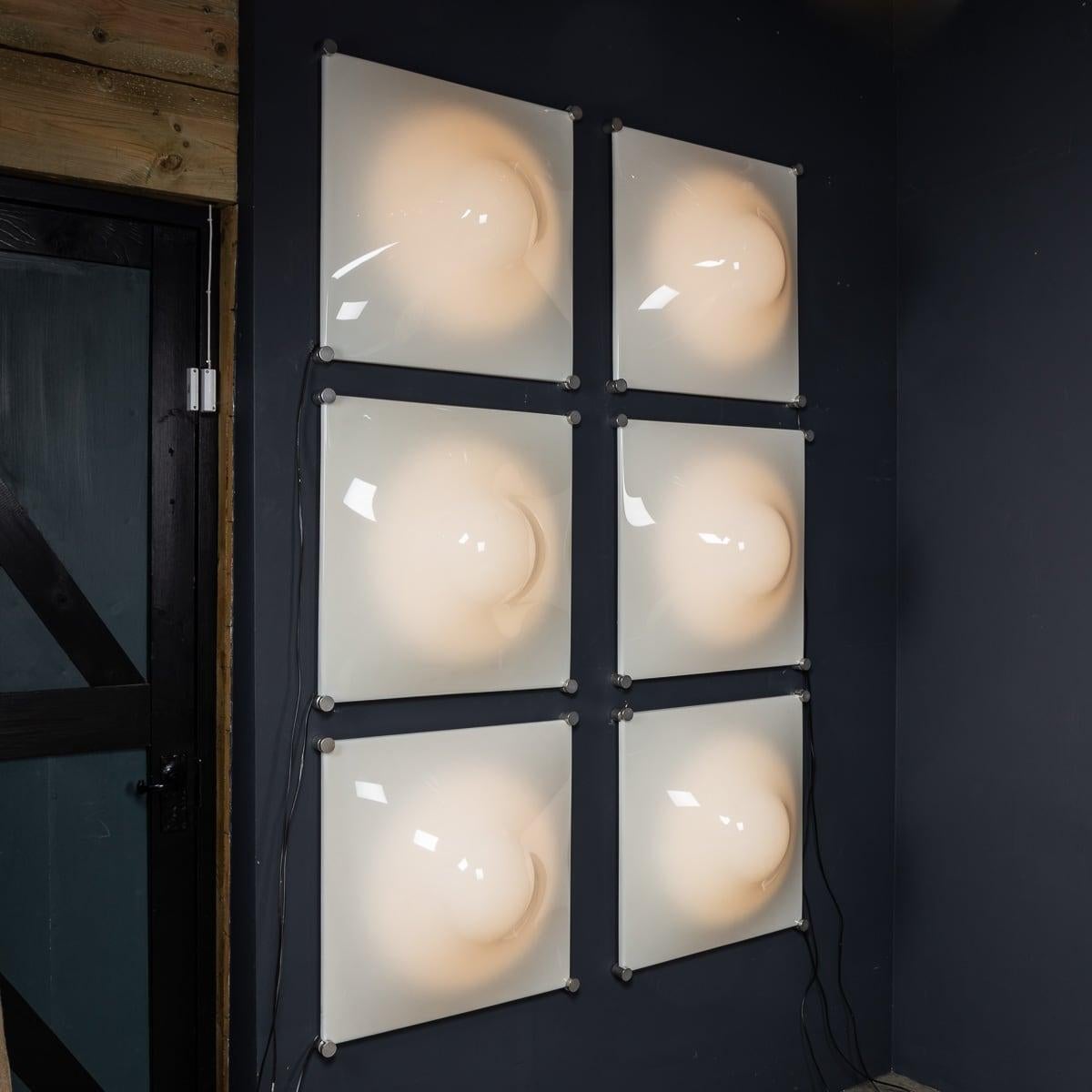 Set di sei applique iGuzzini DADA del 20° secolo, realizzate in perspex bianco con struttura in metallo. Queste iconiche luci incarnano lo stile audace e innovativo dei primi anni '70. Progettata dalla rinomata azienda italiana iGuzzini, nota per le