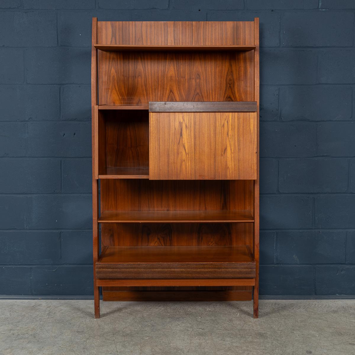 A refined example of Italian mid-century design, this multifunctional bookshelf from the 1960s features clean lines and warm teak construction. Mounted against a fixed vertical teak plank, the piece includes open shelving for books or display, a