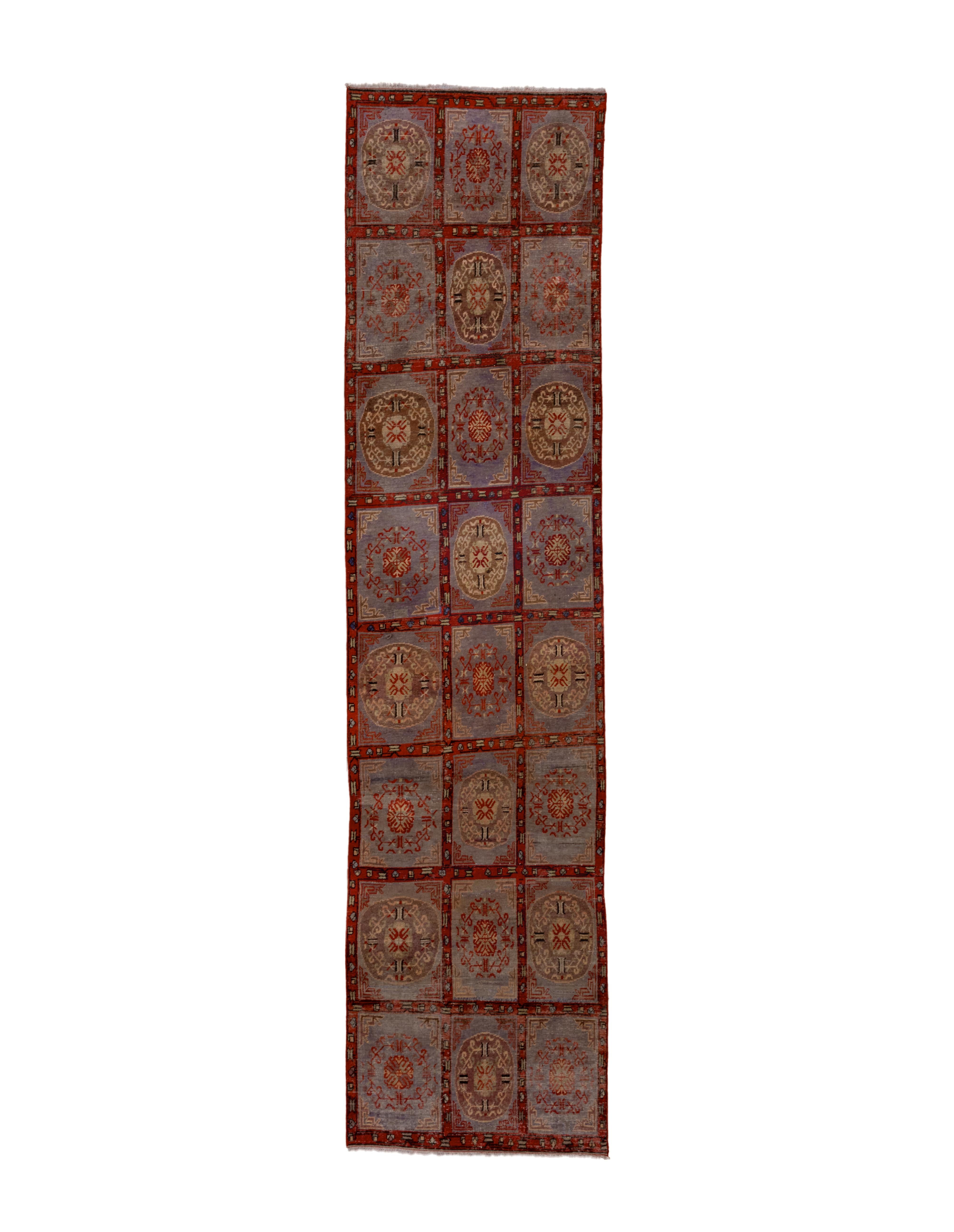 This unusual east Turkestan kenare shows a windowpane field in a three by eight array, all on a light blue ground, with alternations of roundel “moon” medallions with circular openwork wreaths. The narrow border shows the same pattern as the panel