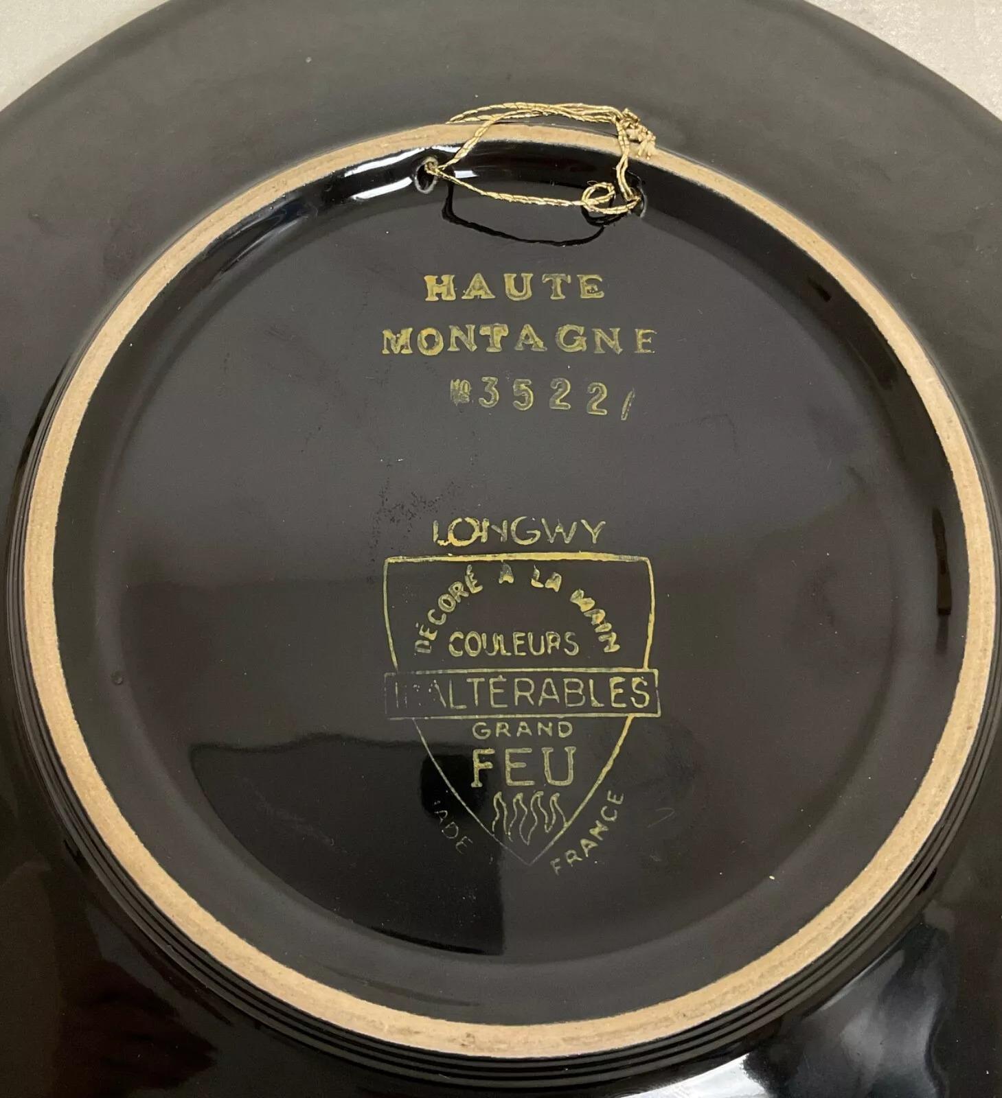 Dieser Emaille-Teller aus dem 20. Jahrhundert von Longwy ist ein wunderschönes Dekorationsstück, das von Hand mit einer ruhigen Bergszene bemalt wurde. Mit einer Höhe von 3 cm (1,2 Zoll), einer Länge von 27 cm (10,6 Zoll) und einer Breite von 26,5