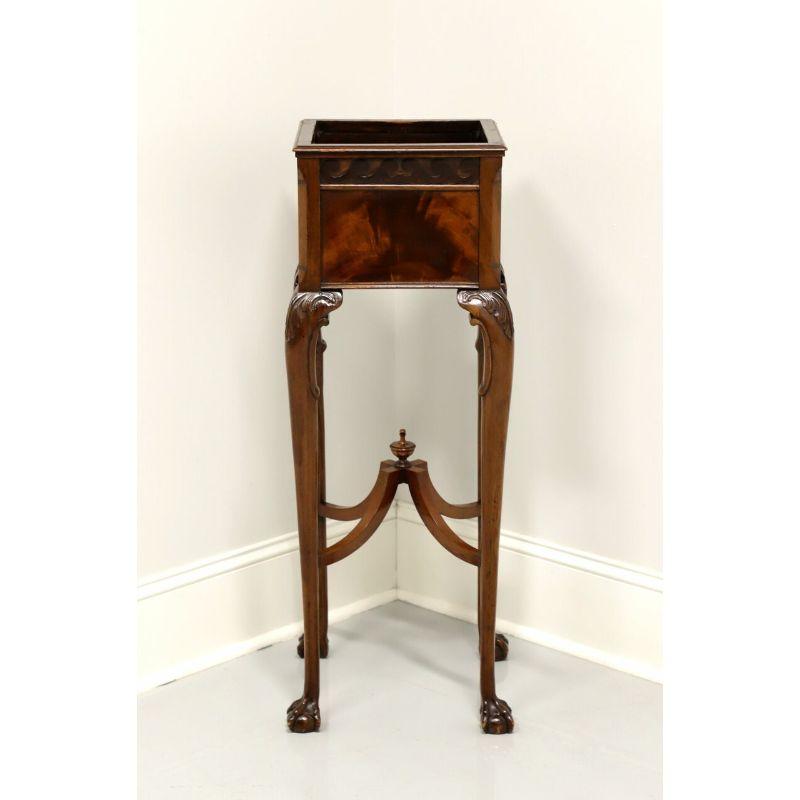 A vintage Chippendale style tall plant stand, unbranded, similar quality to Kindel or Kittinger. Mahogany with flame mahogany, curved stretcher with center finial, cabriole legs, ball and claw feet. Likely made in the USA, in the late 20th