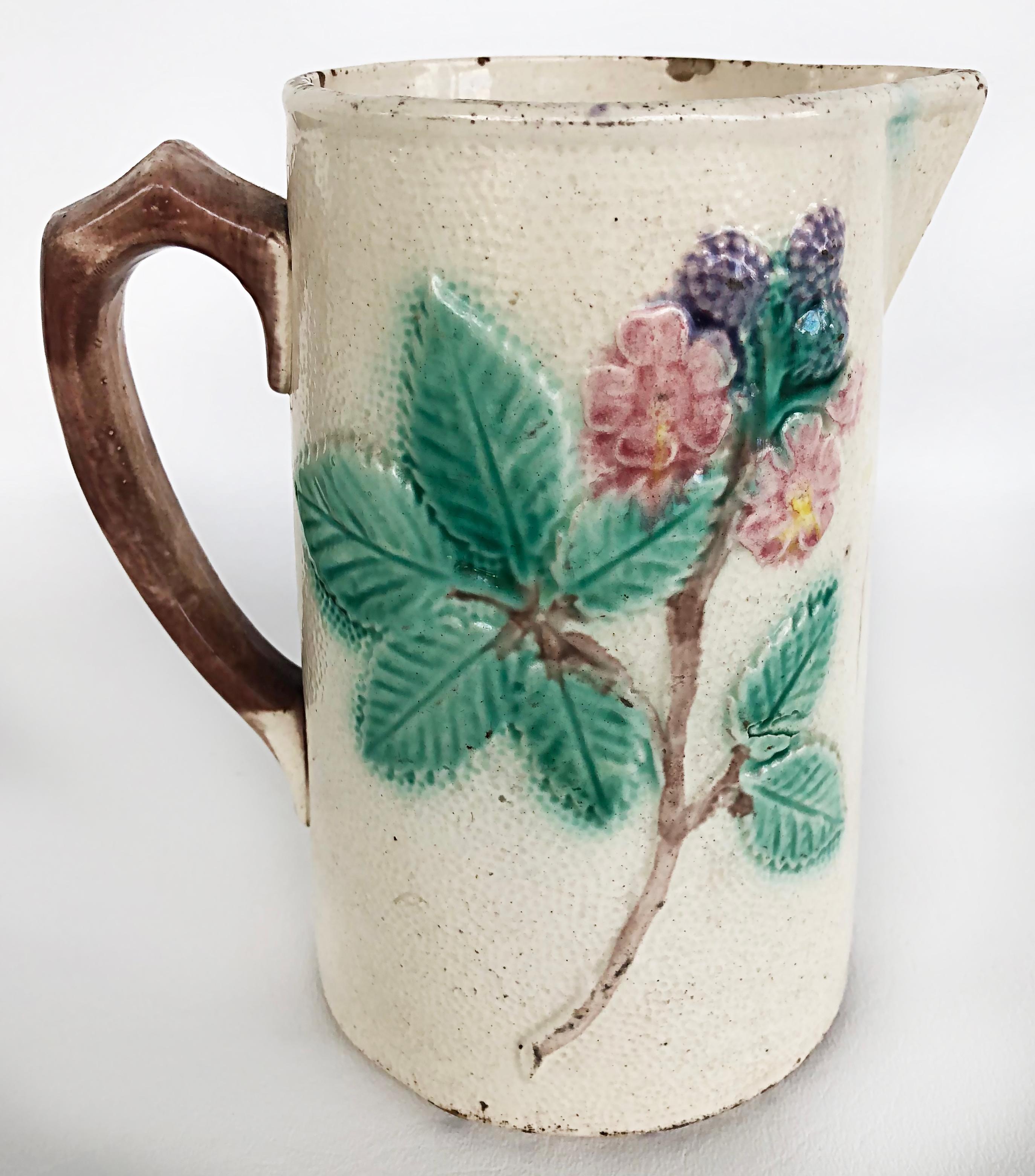 Vintage 20th century Majolica Pitcher with Floral Leaf Designs and berries.

Offered for sale is a late 20th-century majolica pitcher with floral leaf designs and a sprig of berries. The pitcher has a faux bois branch-look handle and is marked