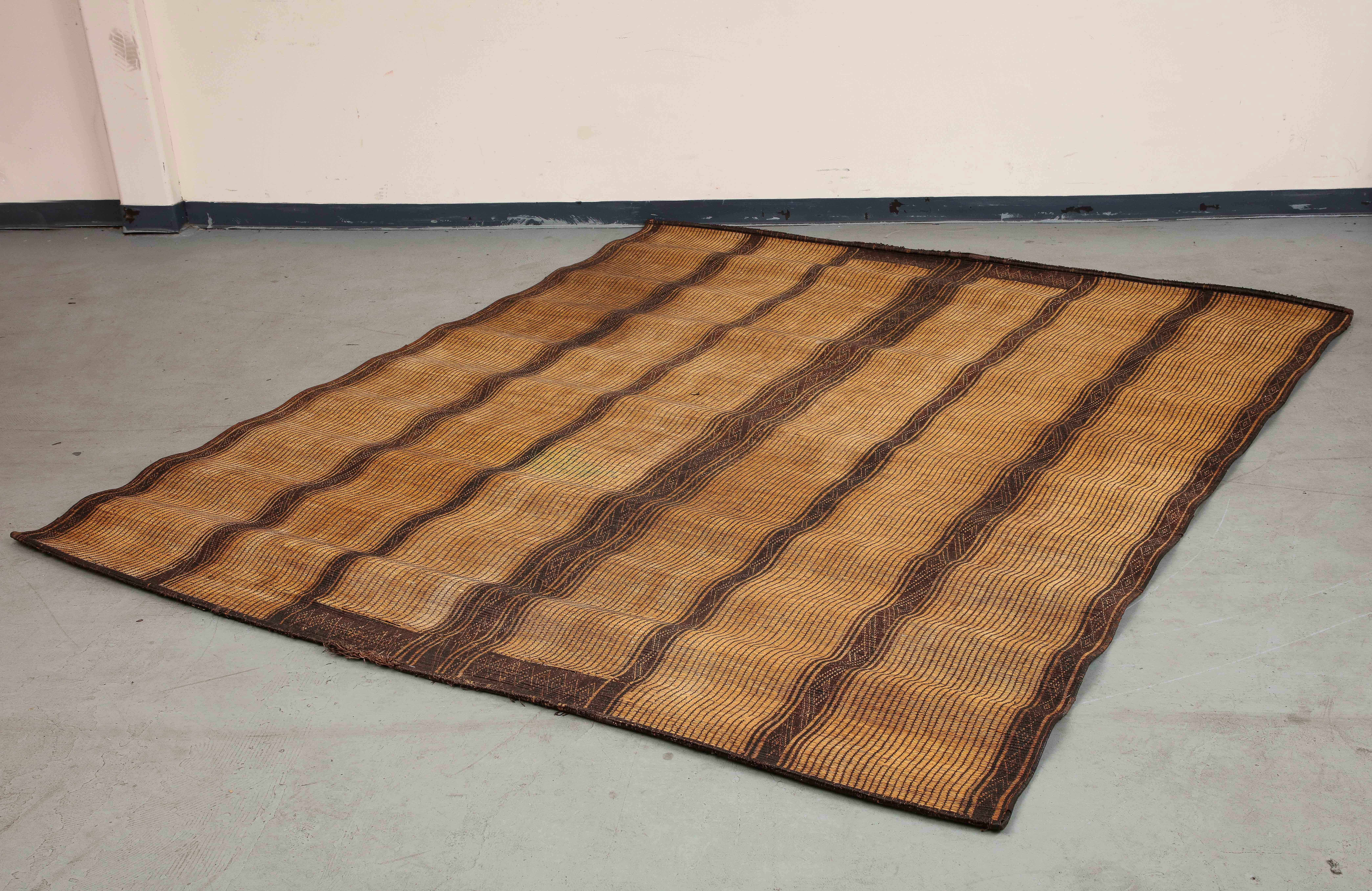 Vintage 20th century Moroccan Tuareg mat rug, made of handwoven reeds. Featuring six wide lighter natural/tan 