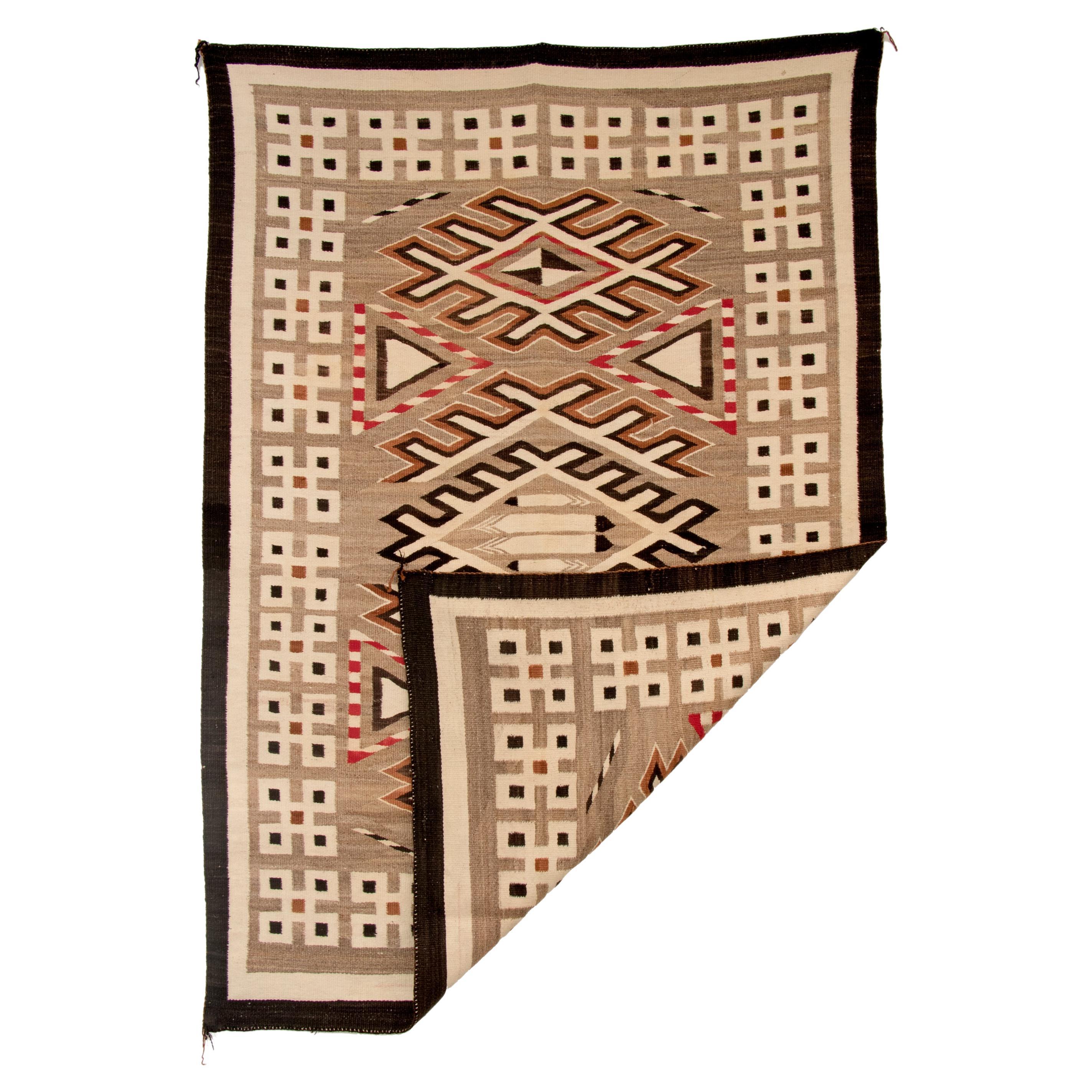 Vintage Navajo rug with a pictorial design from the Trading Post era rug woven of native hand-spun wool in natural fleece colors of ivory, brown and black with aniline red, circa 1900-1925. Central design elements include of three stylized diamonds