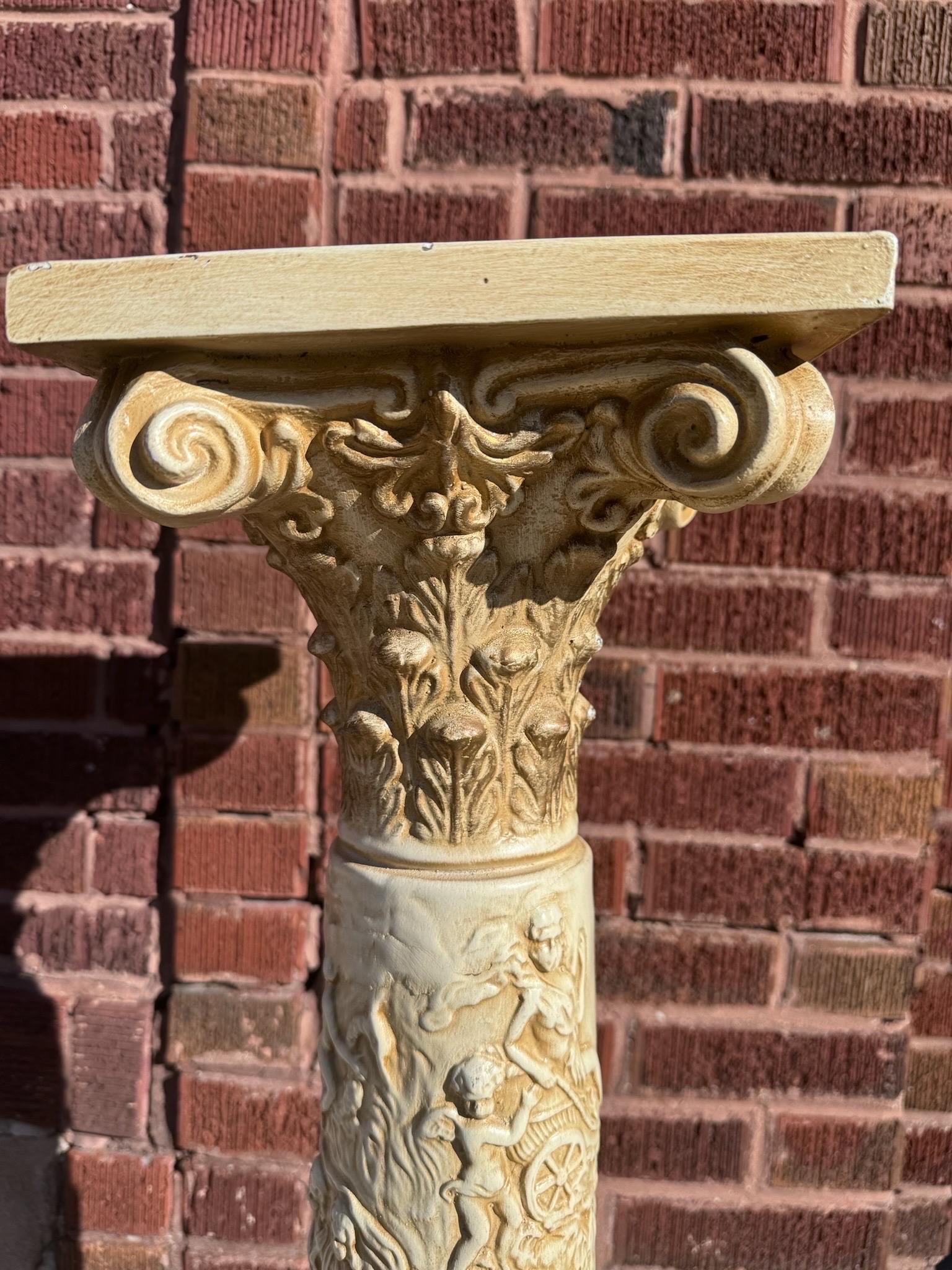 Vintage 20th Century Neoclassical Roman Style Column Stand/Pedestal

Ce piédestal italien orné présente un beau chapiteau à feuilles d'acanthe et une scène mythique sculptée sur la face de la colonne. La scène figurative du pilier contient de