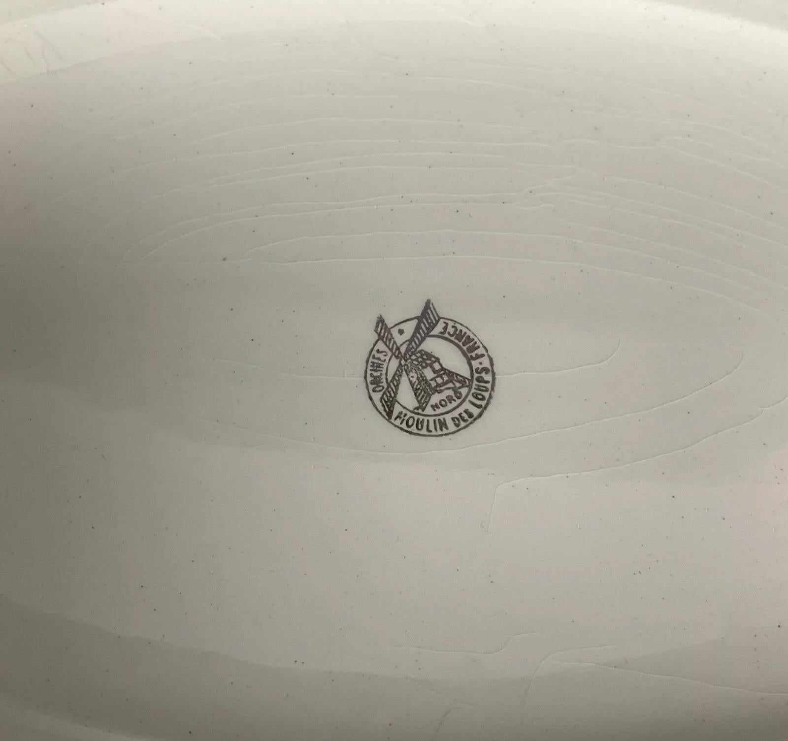 This vintage 20th-century oval serving plate from Moulin des Loups France Orchies is a timeless piece of French ceramic craftsmanship. Measuring 1.4 inches (3.5 cm) in height, 13.2 inches (33.5 cm) in length, and 9.3 inches (23.5 cm) in width, the