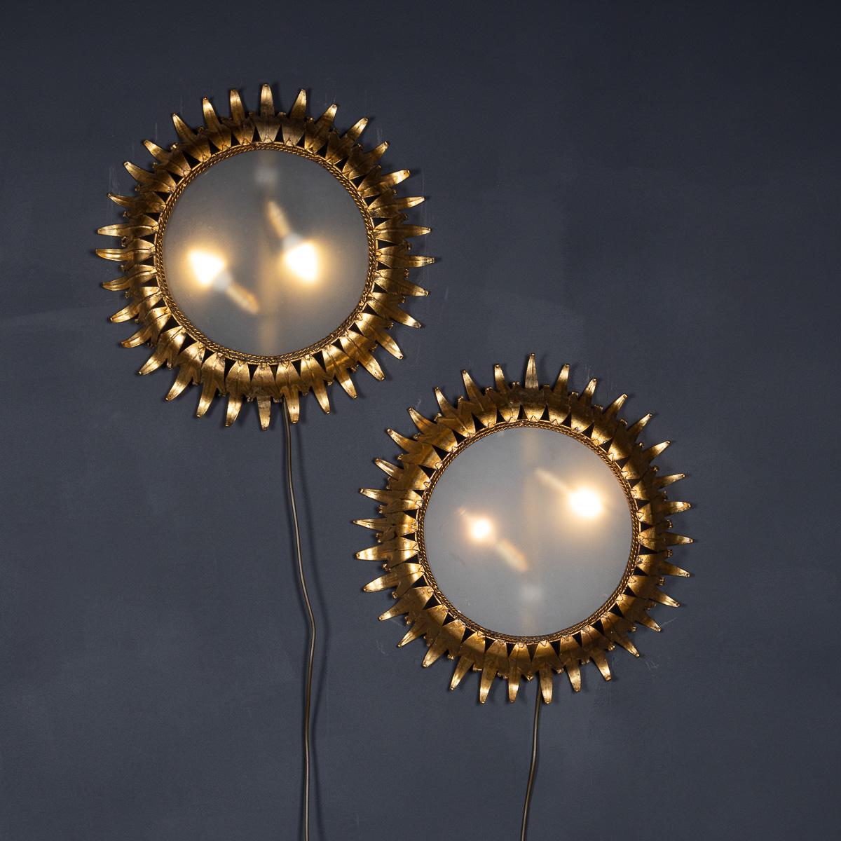 Coppia di applique circolari in vetro fumé del XX secolo con una cornice di foglie in ottone che crea un'impressione di sole. Ogni lampada presenta due lampadine sotto il disco di vetro. Un'aggiunta superba a qualsiasi casa, sia moderna che