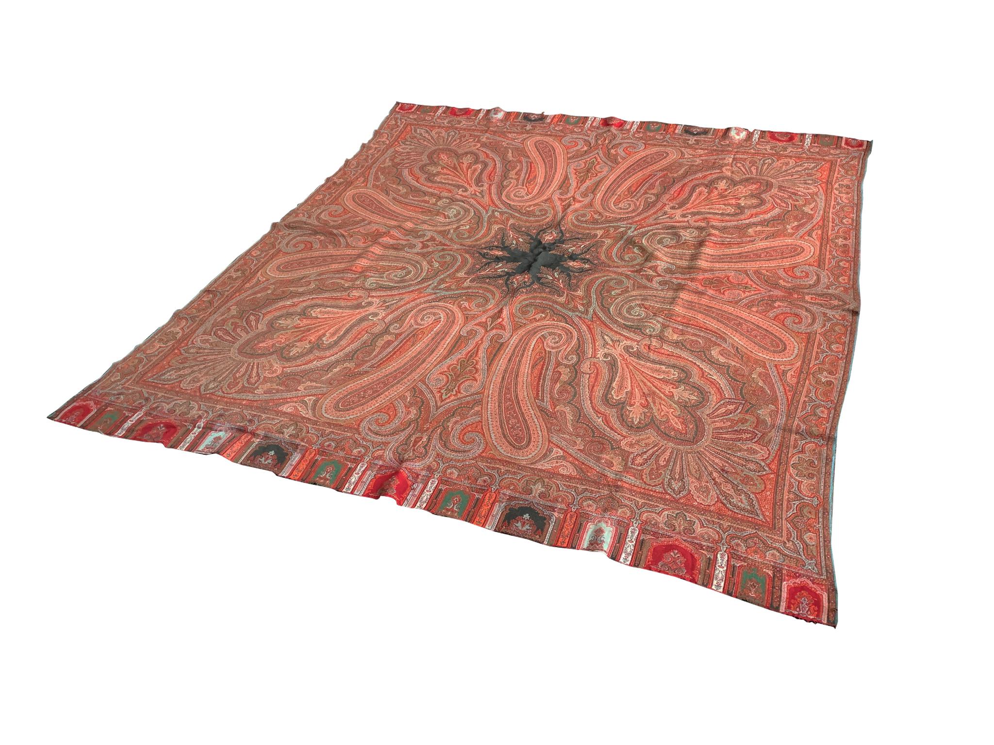 Eine dekorative Decke im Vintage-Stil mit einem auffälligen Paisleymuster. Die Farbpalette ist eine bunte Mischung aus Rot, Orange und Rosa mit Akzenten in Grün, Weiß und Schwarz. Es ist eine sehr schöne Komposition, die einen Raum mit