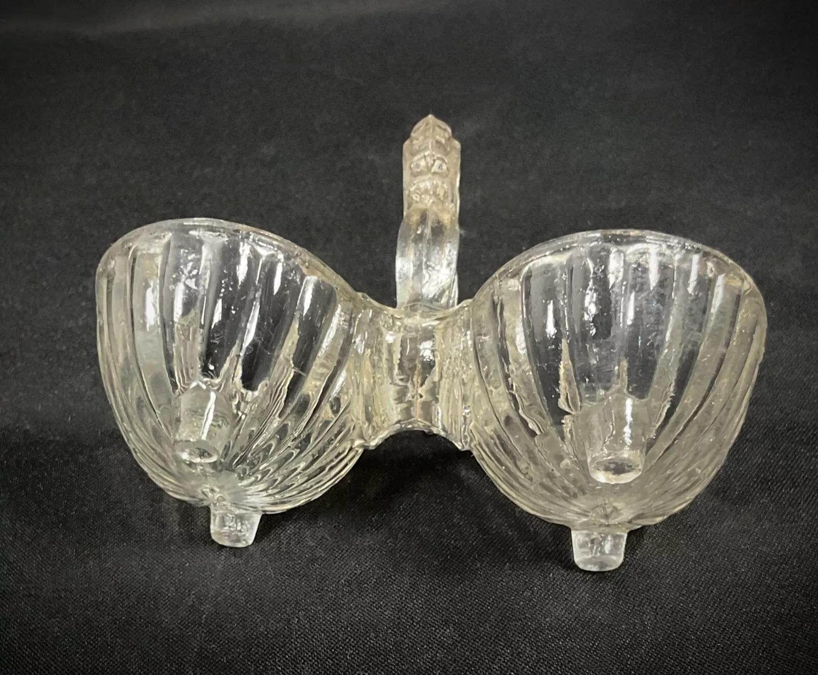 This vintage 20th-century quadripod glass salt cellar is a charming addition to any table setting or kitchen collection. Measuring 3 inches (7.5 cm) in height, 4.1 inches (10.5 cm) in length, and 2.8 inches (7 cm) in width, this lovely salt cellar