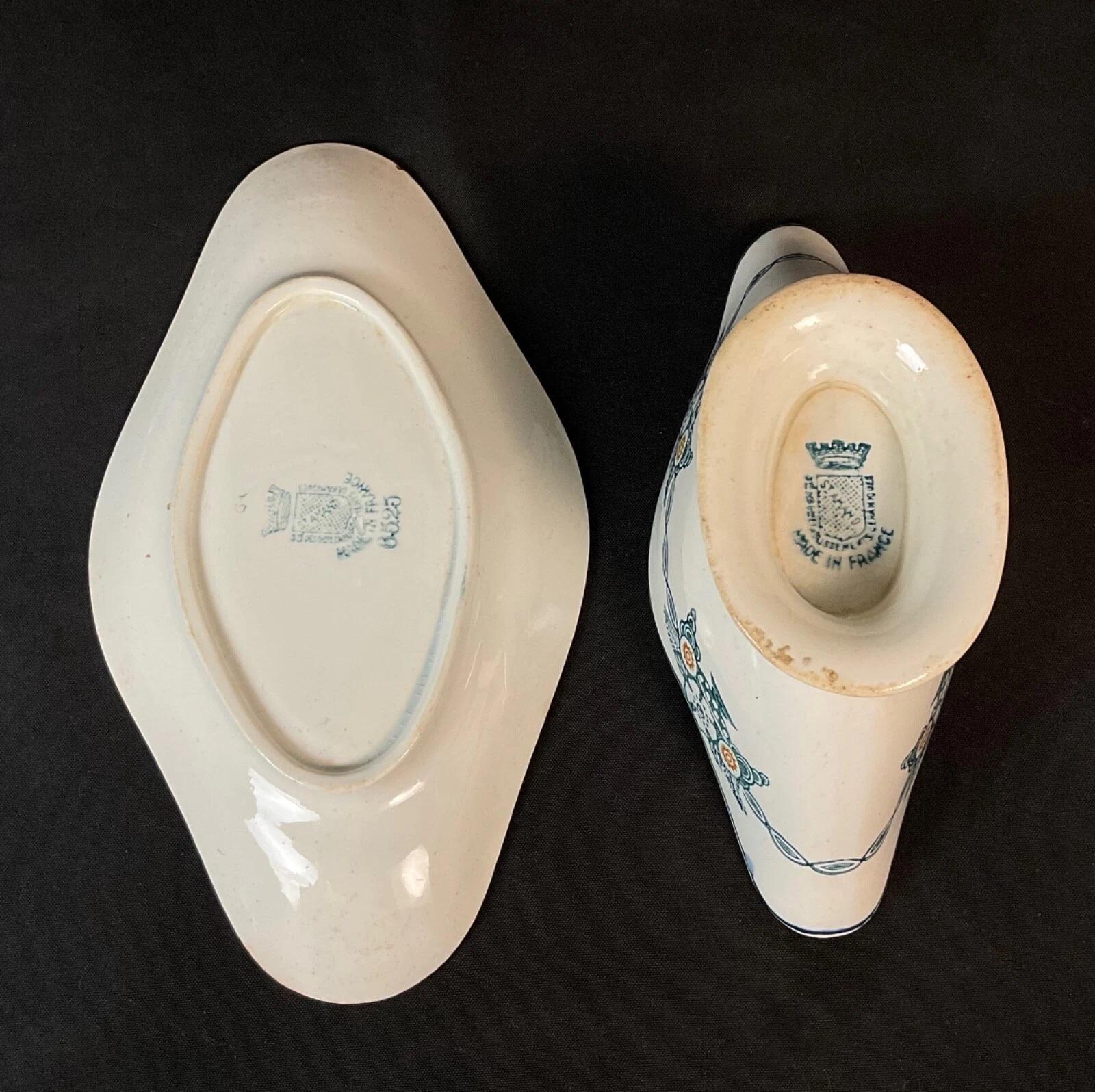 Vintage St Amand Ceramic Sauce Boat Set
This is a vintage ceramic sauce boat and underplate set from St Amand, France, a region known for its quality earthenware. Dating to the 20th century, the set features a charming hand-painted floral decor in