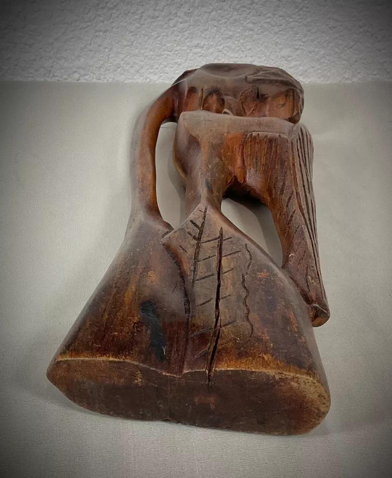 Esta escultura vintage de madera del siglo XX, que representa a una pareja africana, es una cautivadora obra de arte. Con unas medidas de 41,5 cm de altura, 13,5 cm de longitud y 4 cm de grosor, esta elegante escultura pesa 932 g y luce detalles