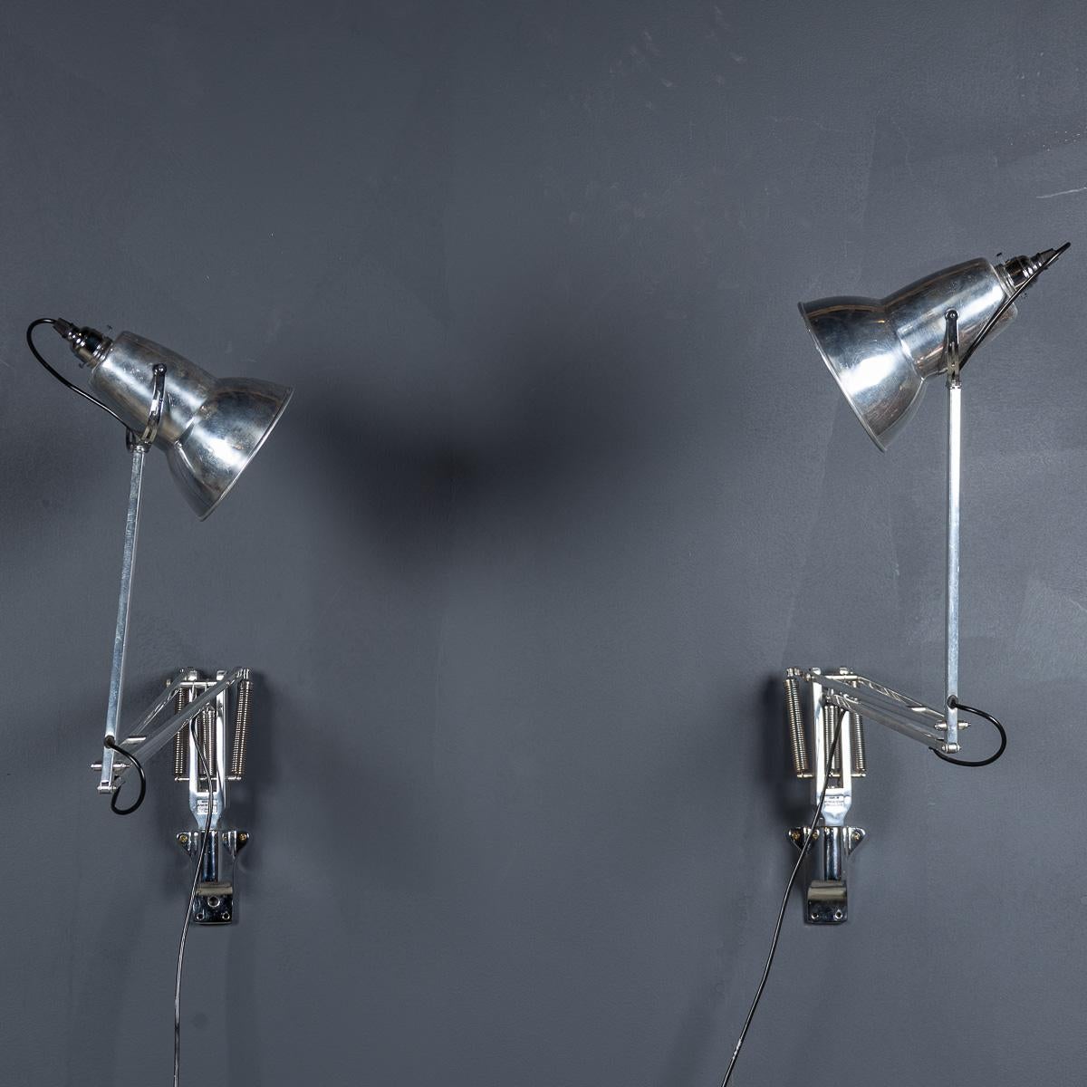 Un par de lámparas de pared inglesas del siglo XX Angle Poise, que ejemplifican el diseño británico clásico para el espacio de trabajo. Con brazos y pantallas ajustables, estas lámparas ofrecen un posicionamiento preciso, montadas en la pared para