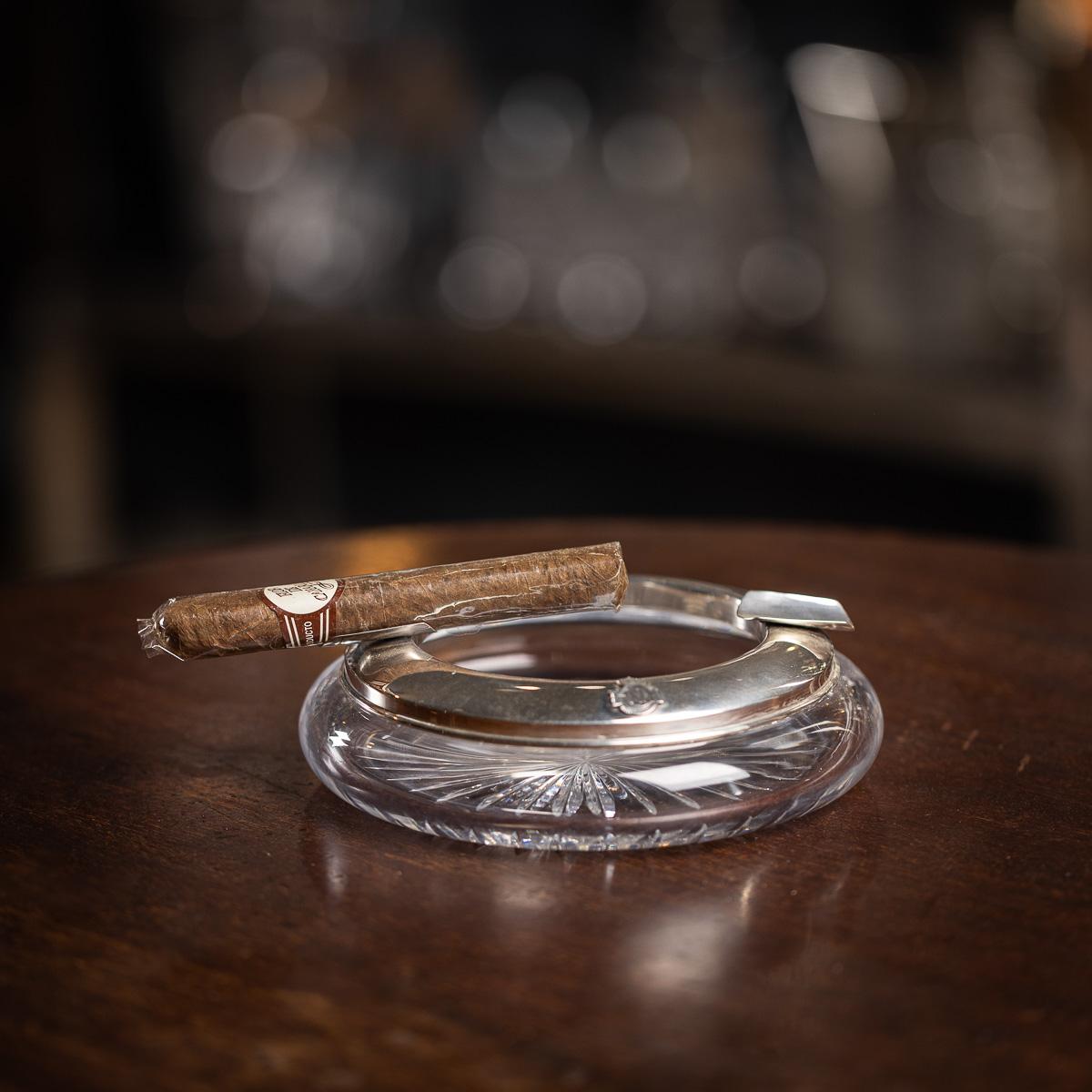 Cendrier vintage du 20e siècle en métal argenté et verre taillé, orné d'un insigne de la marine sur la face avant. Le bord est également orné de deux repose-cigares. Il est facile d'imaginer l'attrait de ces objets qui auraient fait de magnifiques